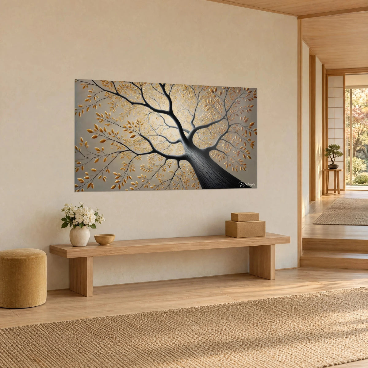 Tableau ramure noire aux feuilles d'or sur fond grège, accroché haut sur un mur crème, banc en bois clair, couloir japandi