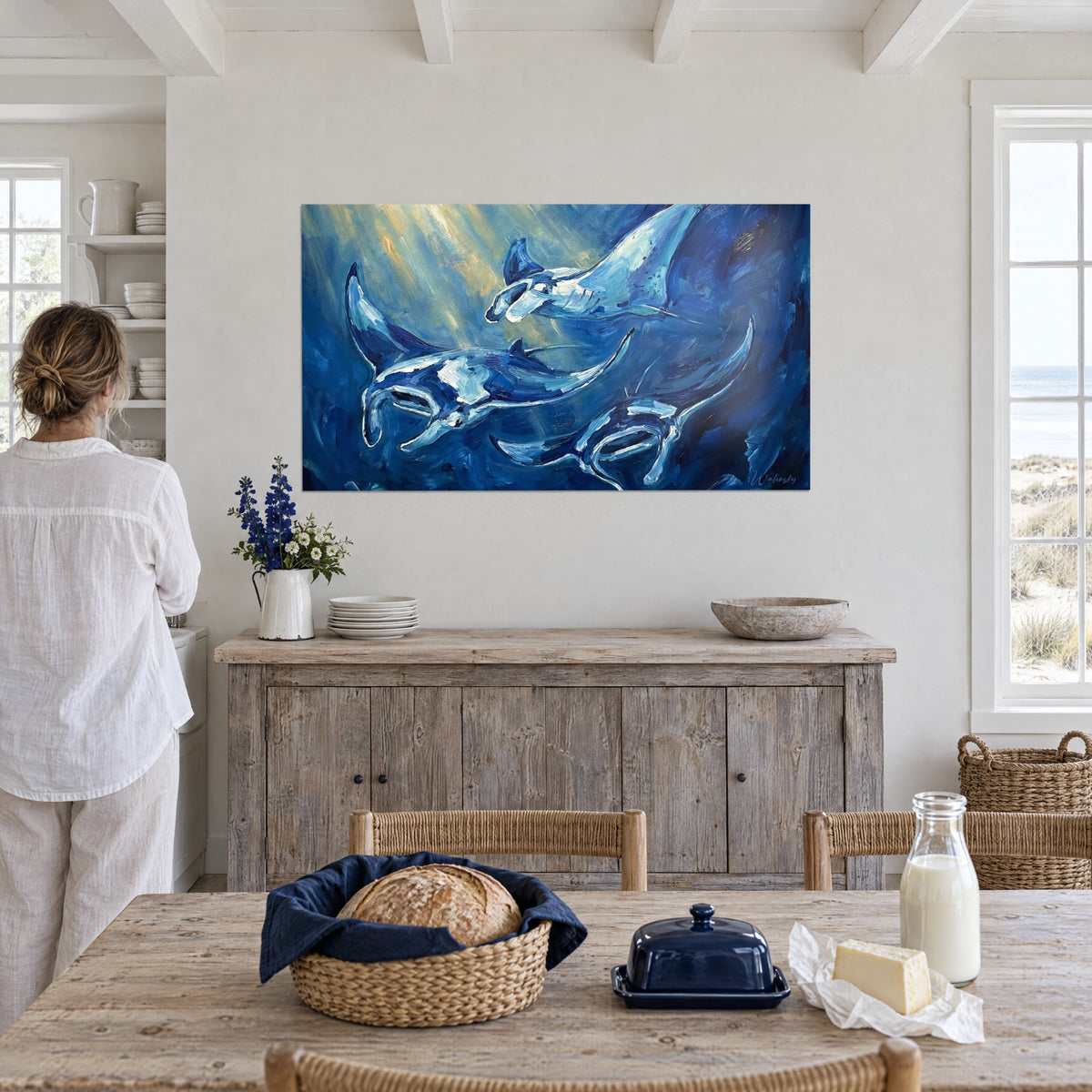 Tableau mantas aux ailes déployées, empâtements bleu roi et blanc pur, rayons jaune pâle, mur blanc devant des dunes, bord de mer