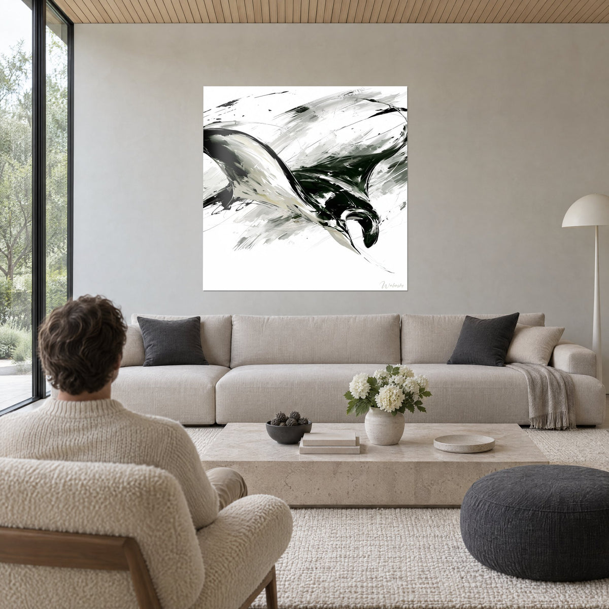 Wall art black manta ray diving, white wing and gray brushstrokes, above a sofa in a bright living room