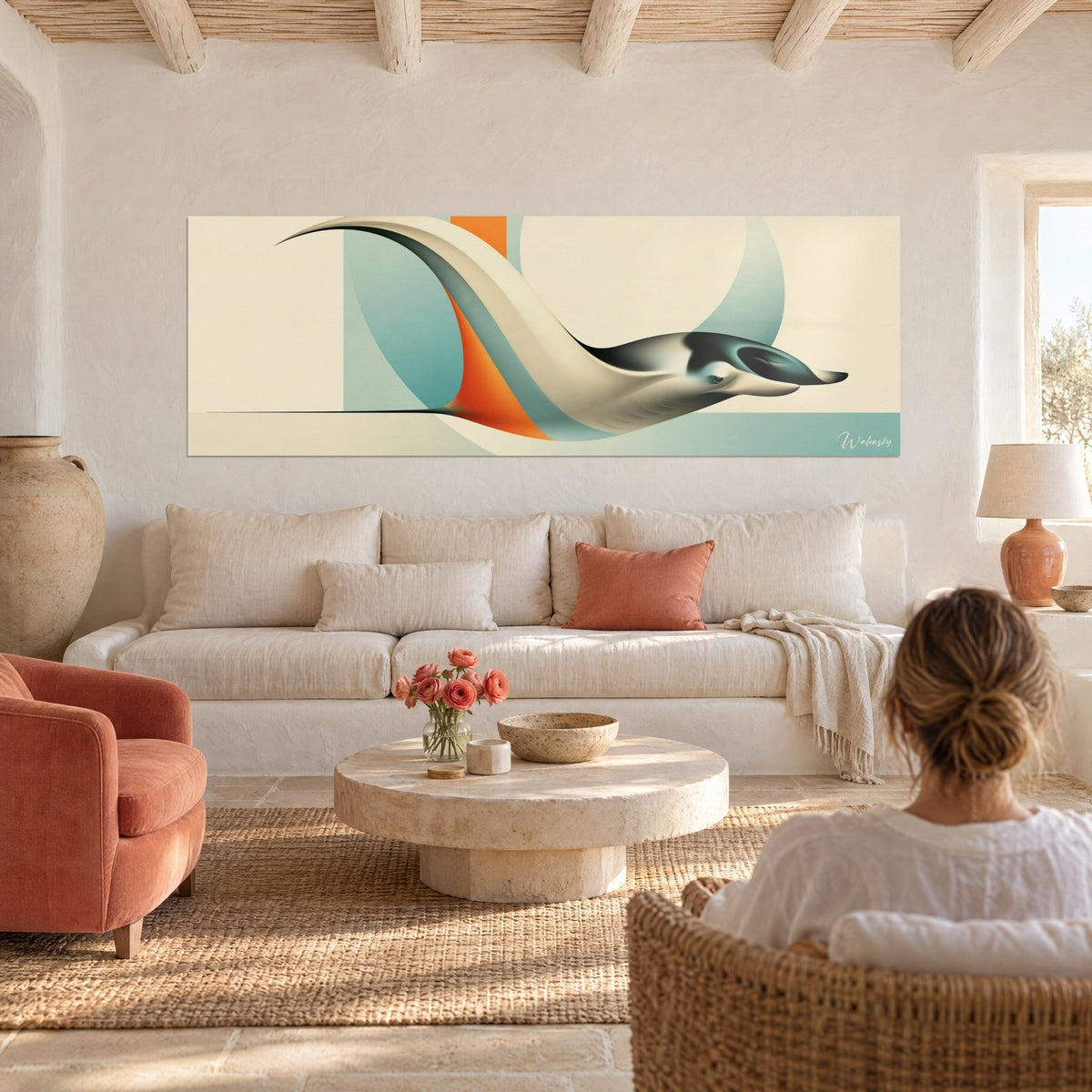 Wall art ivory manta ray gliding over a turquoise background, orange circle, two people seen from behind above a sofa in a bright living room