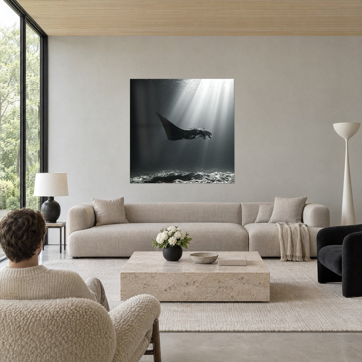 Gemälde Mantarochen schwarz gleitend in einem silbernen Lichtstrahl, anthrazitgrauer Hintergrund, über einem Sofa in einem hellen Wohnzimmer