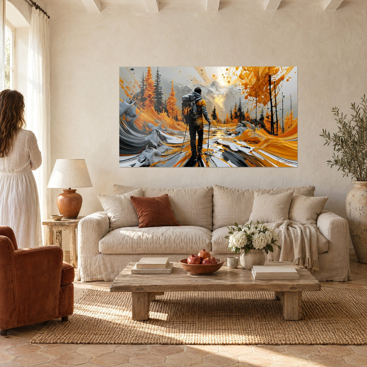 Quadro di un escursionista con zaino grigio e bastoncini in mano, larici ocra e vetta argentata, coppia che lo ammira sopra un divano in un soggiorno luminoso