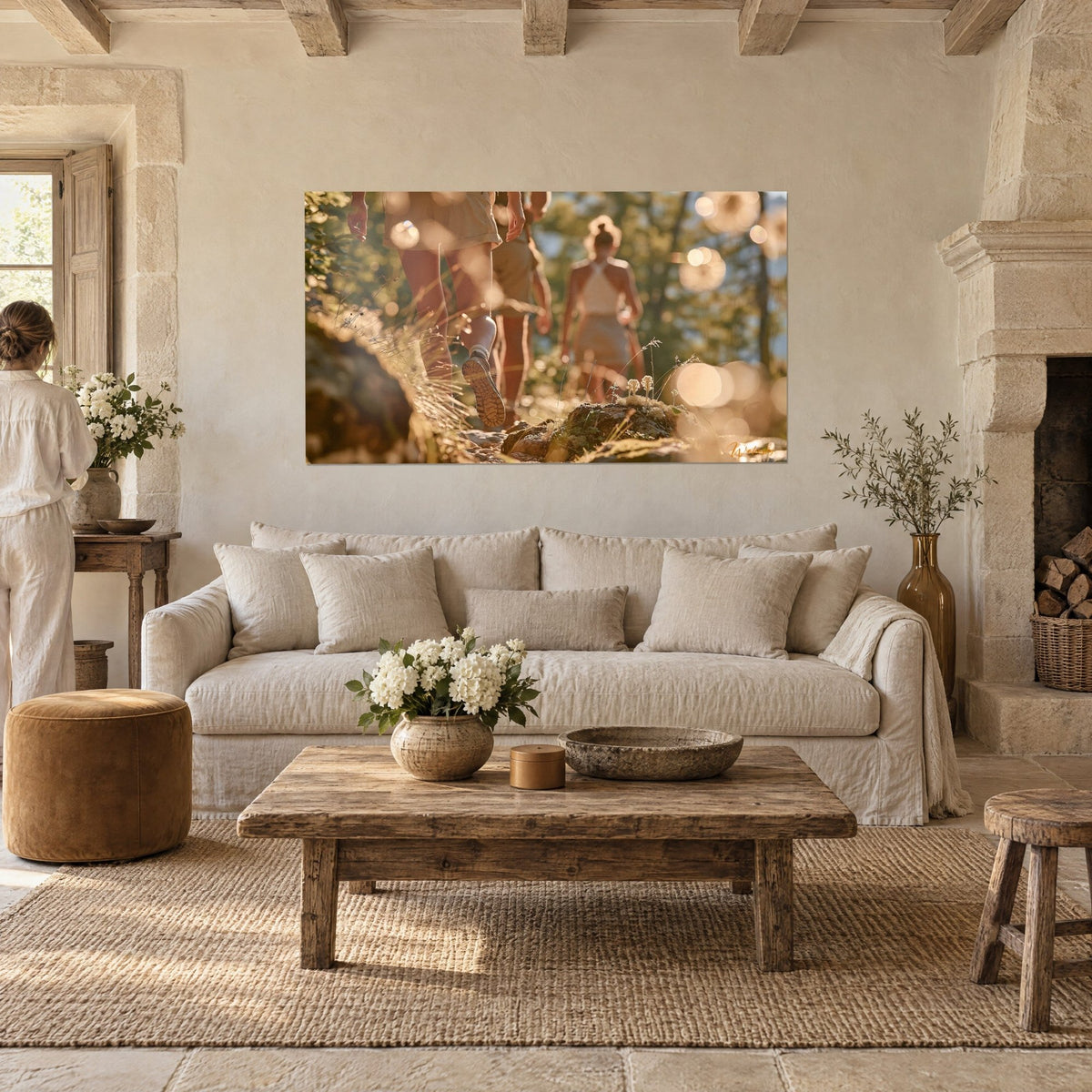 Wall art hikers in beige shorts on a trail, lugged sole and golden bokeh, above a sofa in a bright living room