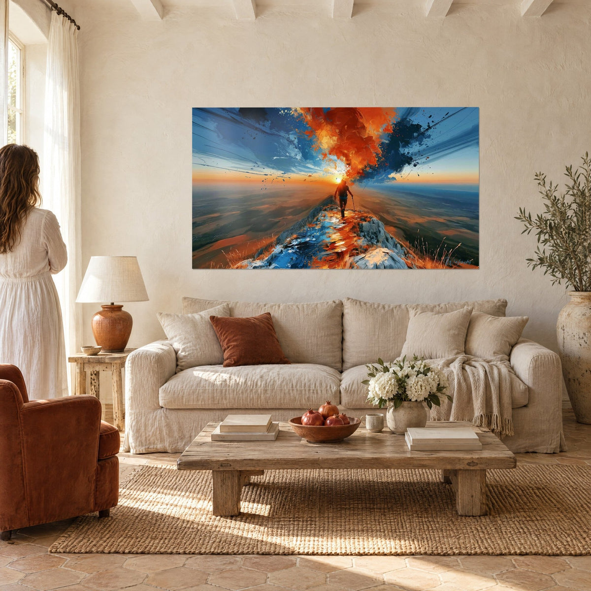 Tableau randonneur de dos sur une crête rocheuse, ciel orange flamboyant et bleu nuit, bâton en main, au-dessus d'un canapé dans un salon lumineux