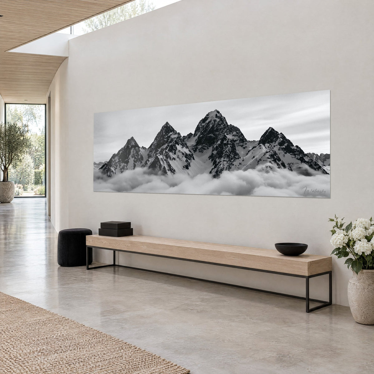 Gemälde panoramische Alpenkette, die aus einem Nebelmeer aufragt, anthrazitfarbene Gipfel und perlgrauer Himmel, beige Wand eines Architektenhauses