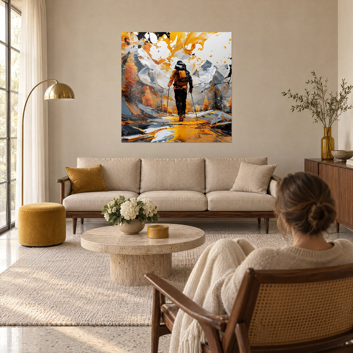 Tableau randonneur de dos aux bâtons dans un sentier ocre, montagnes blanc et gris, mélèzes dorés, au-dessus d'un canapé dans un salon lumineux