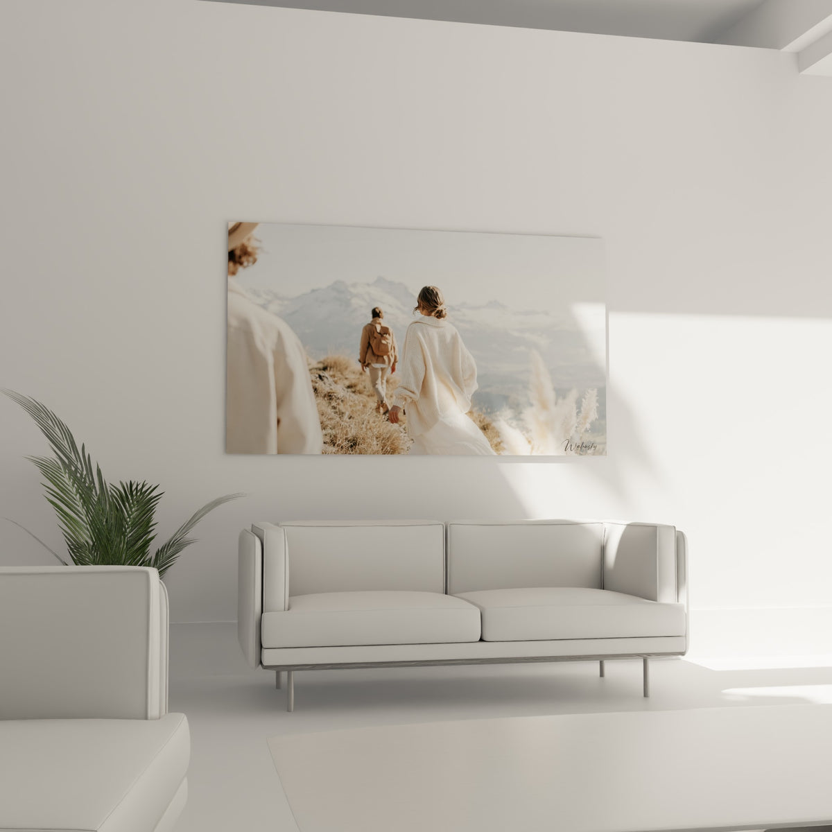 Silhouettes en pull écru et manteau camel gravissant un sentier, au-dessus d'un canapé dans un salon lumineux