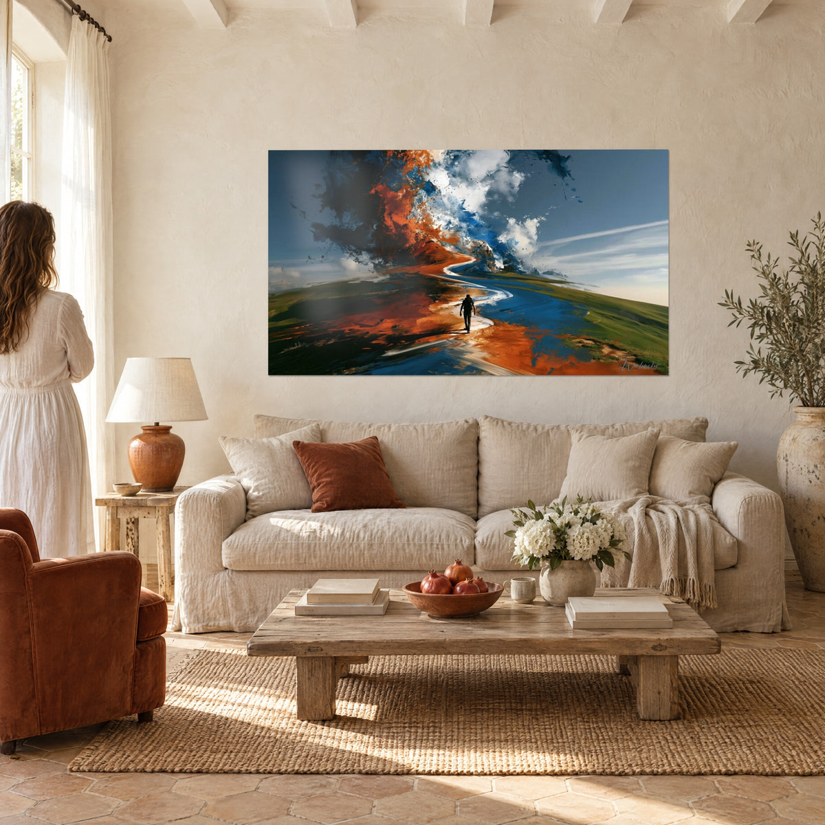 Wall art of a silhouetted hiker on an orange and blue trail, swirling cloud, woman seen from behind, above a sofa in a bright living room