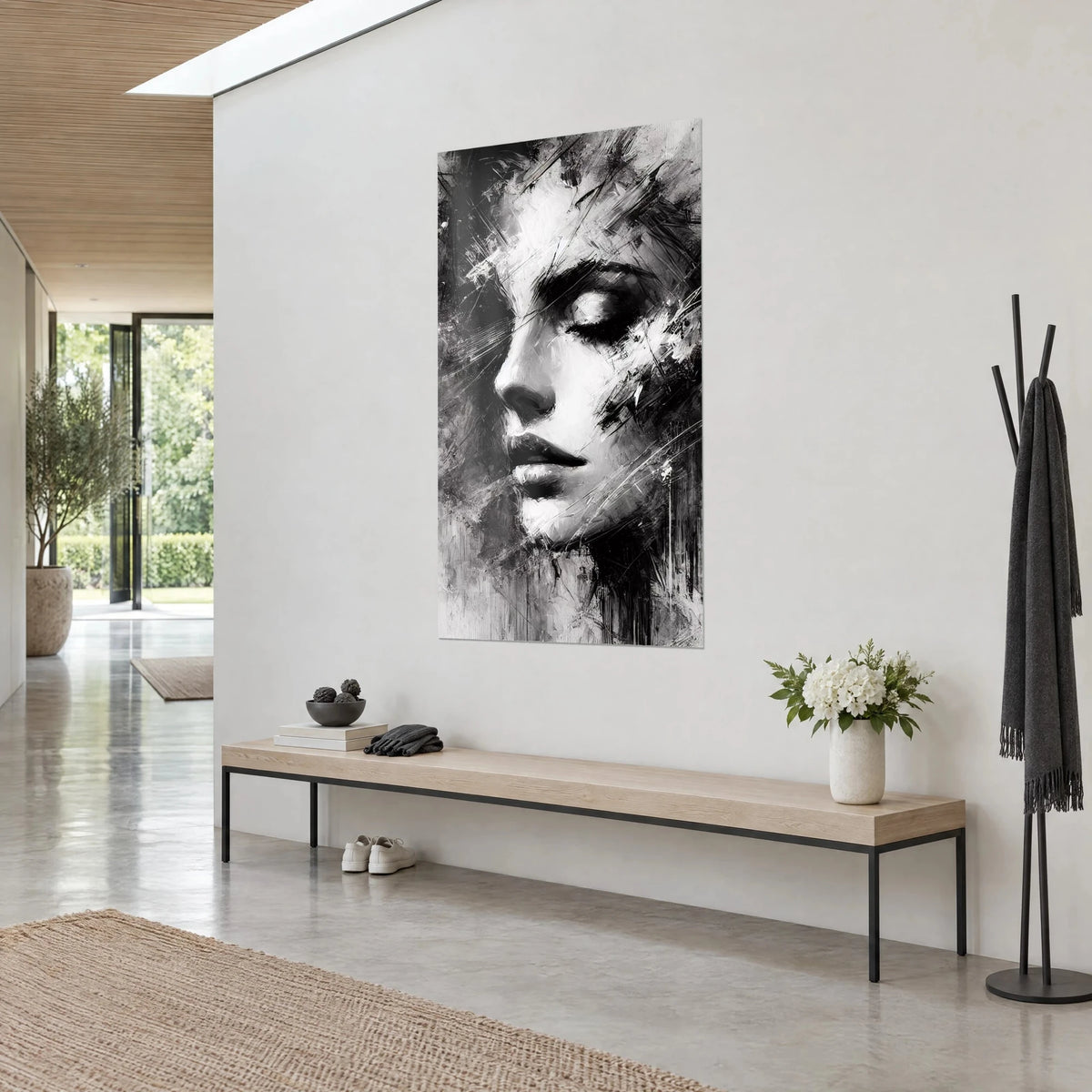 Tableau portrait féminin fragmenté, joue blanche et ombres charbon, vu de trois-quarts sur un mur gris près d'un banc en bois clair