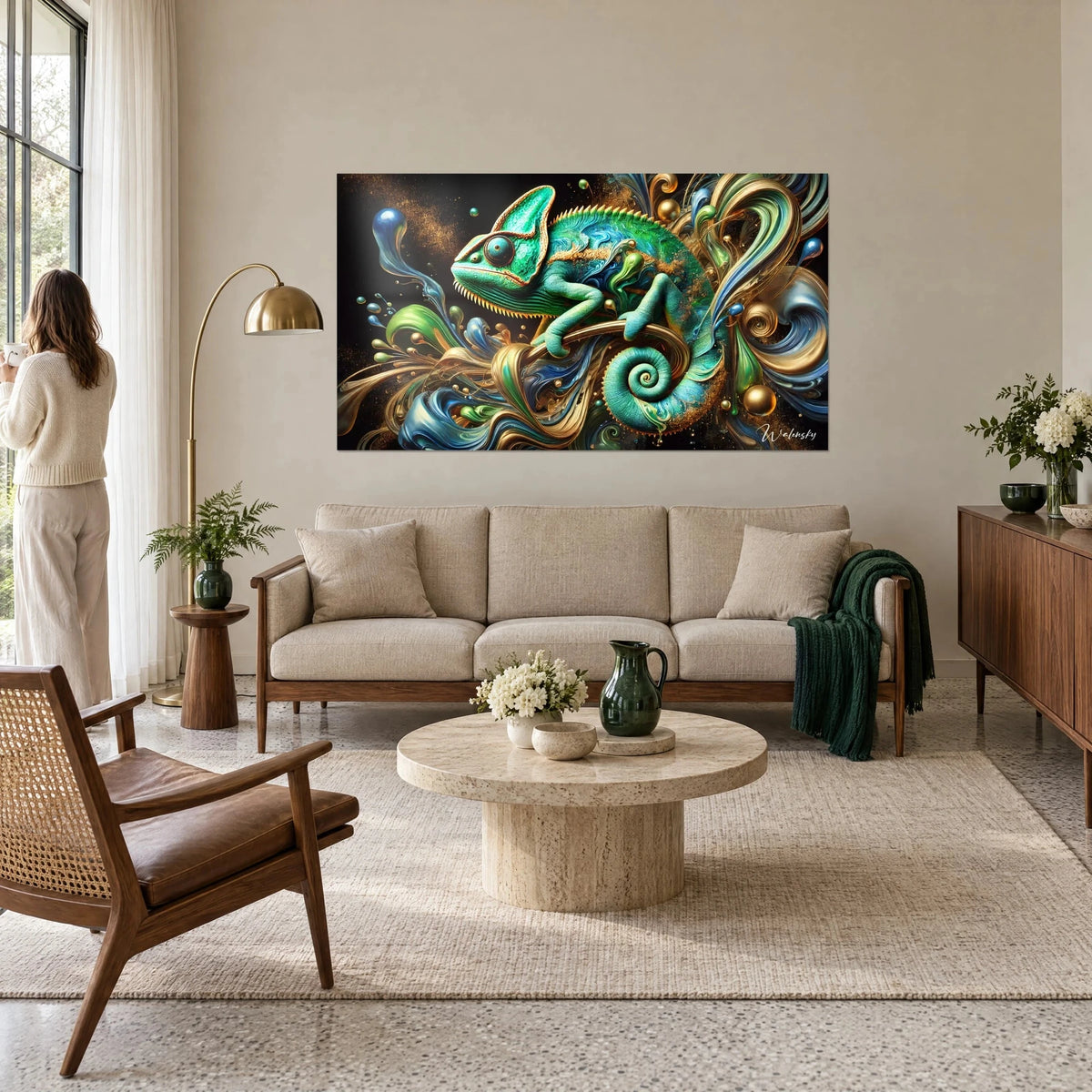 Tableau caméléon émeraude lové sur une branche dorée, volutes bleues, femme de dos, au-dessus d'un canapé dans un salon lumineux