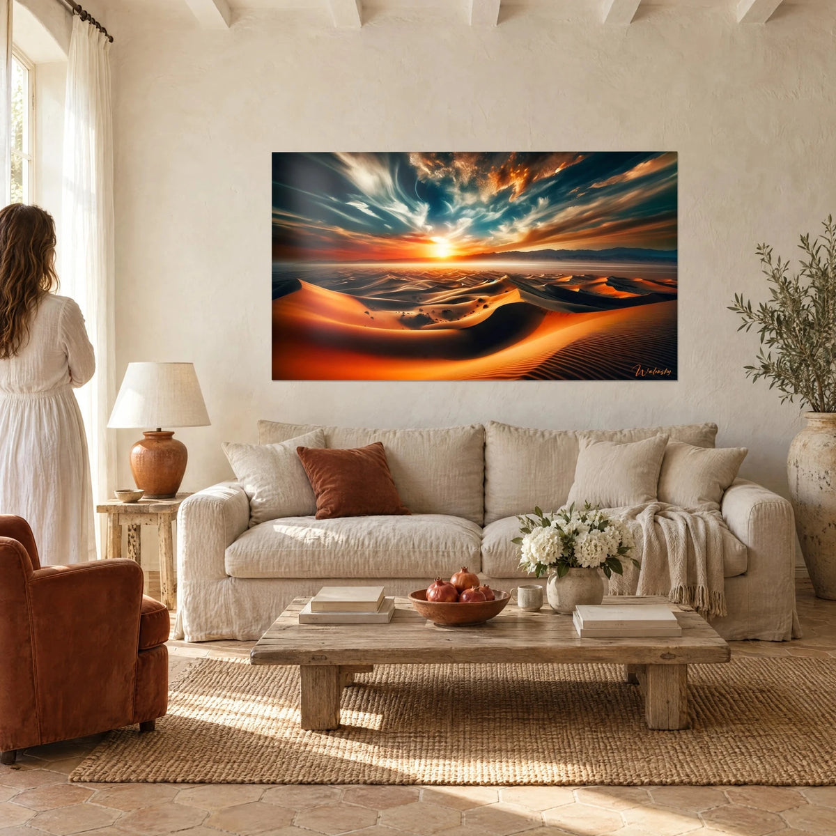 Gemälde mit schmelzenden orangefarbenen Dünen unter einem nachtblauen, wolkengestreiften Himmel, tiefstehende Sonne am Horizont, über einem Sofa in einem hellen Wohnzimmer