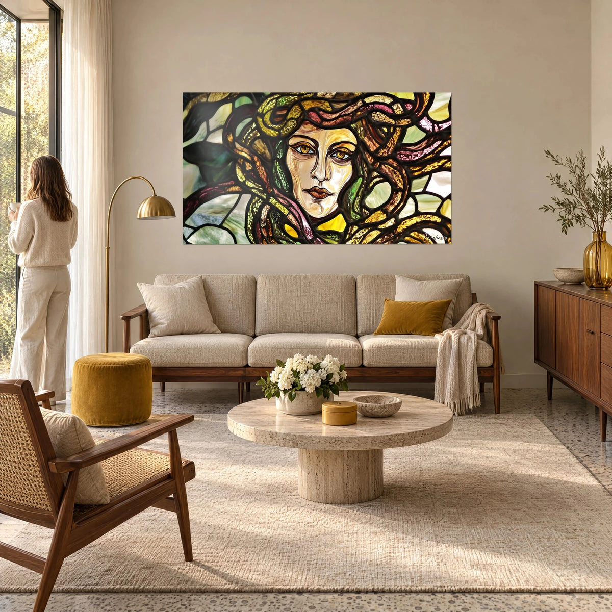Tableau Méduse en vitrail aux yeux ambrés, serpents rosés et verts, au-dessus d'un canapé dans un salon lumineux