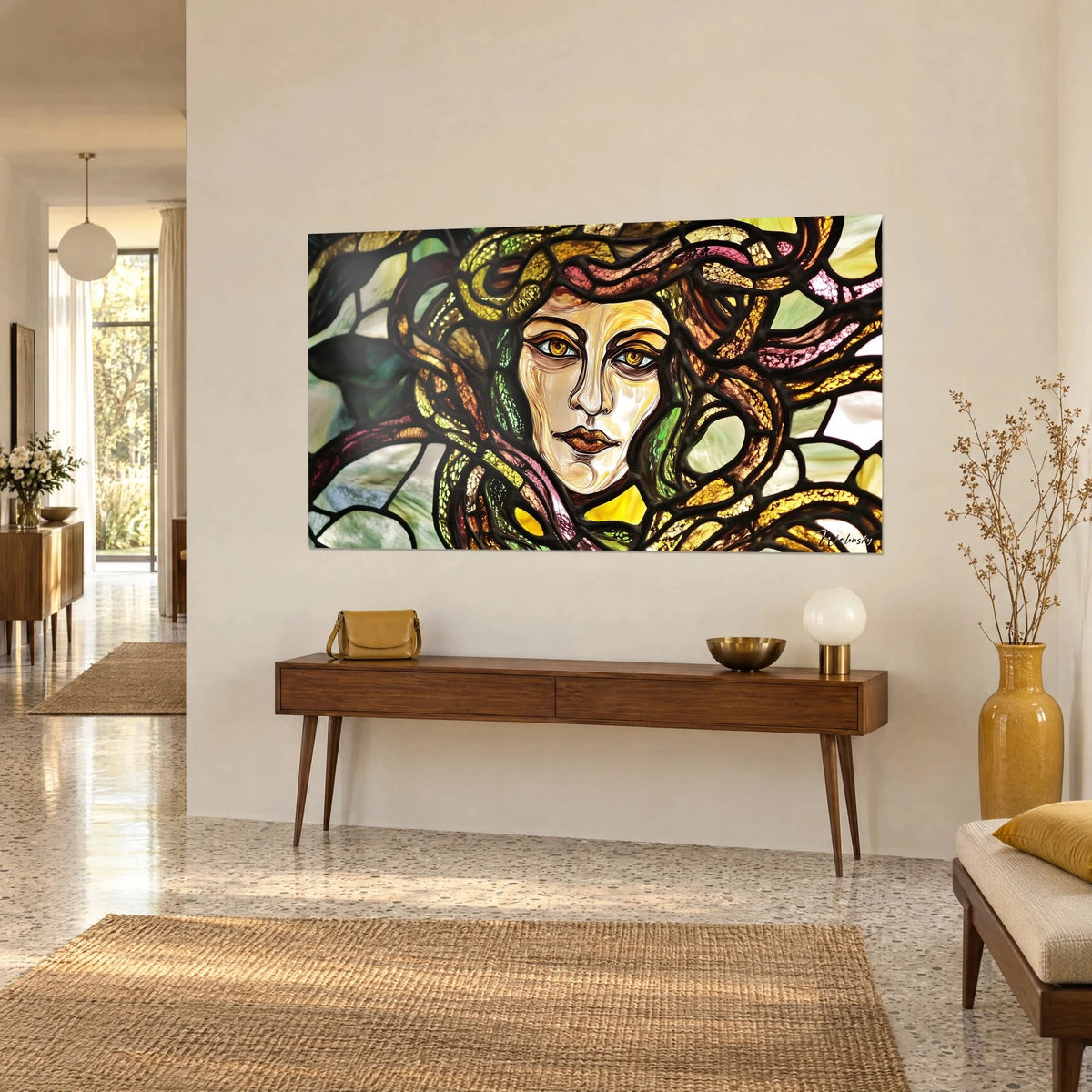 Tableau visage de gorgone cerné de plomb noir, mèches jaune miel et bordeaux, sur un mur beige près d'une console