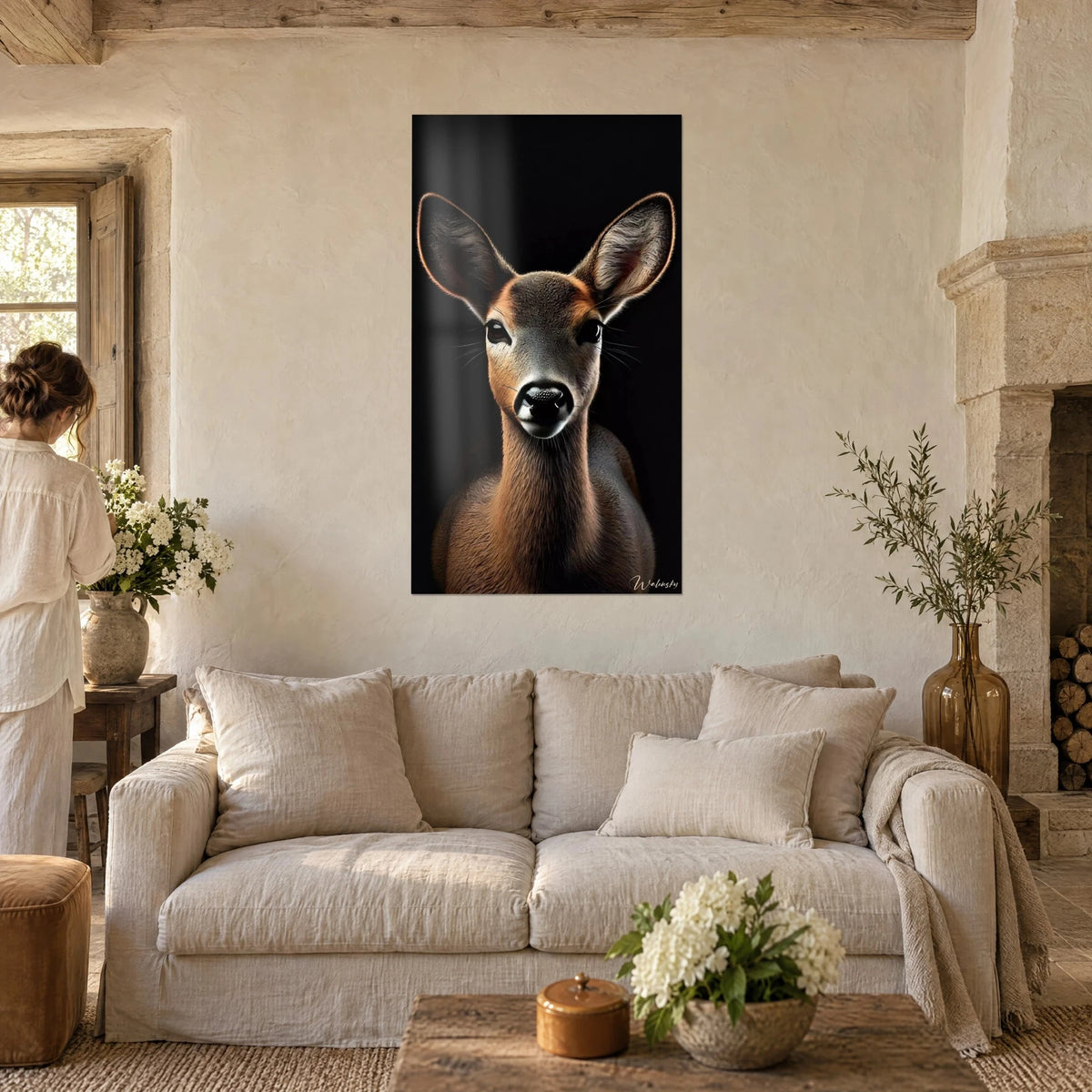 Tableau jeune biche aux grandes oreilles, pelage cuivré sur fond noir, accroché au-dessus d'un canapé dans un salon lumineux
