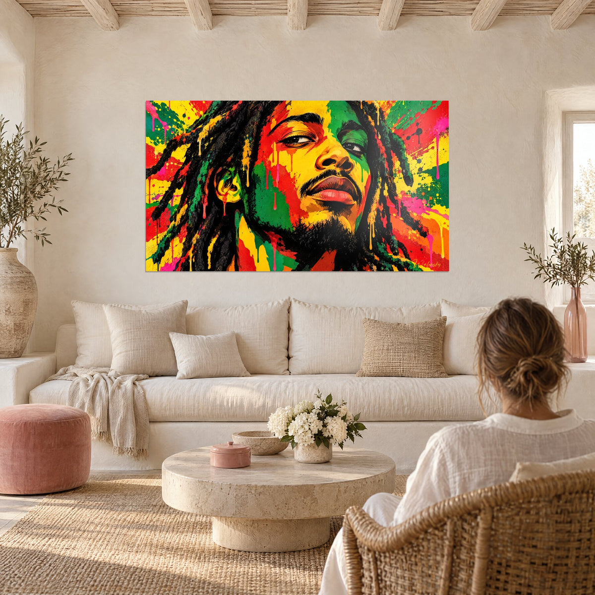 Tableau chanteur aux dreadlocks noirs, visage éclaboussé de jaune, vert et rouge, au-dessus d'un canapé dans un salon lumineux