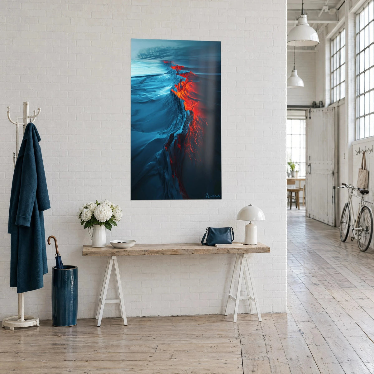 Tableau crevasse incandescente orange tranchant un désert glacé bleu, vue de trois-quarts, console en bois, loft clair