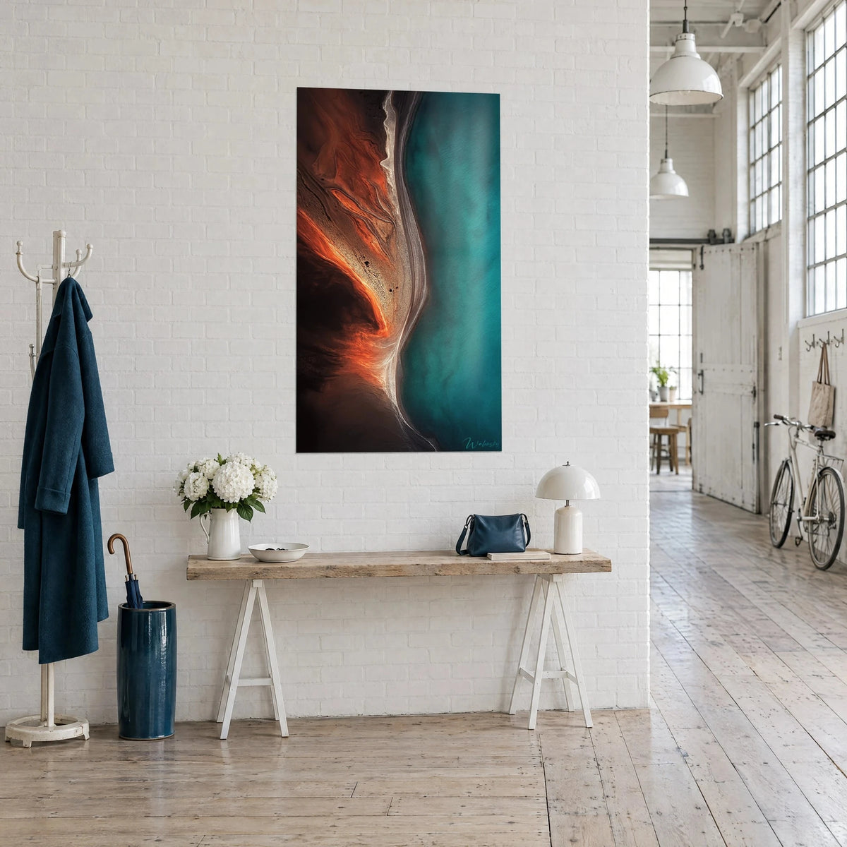 Schilderij strand met koperkleurige aders, petrolgroen water en crèmekleurig zand, aan een witte muur van een kunstenaarsloft