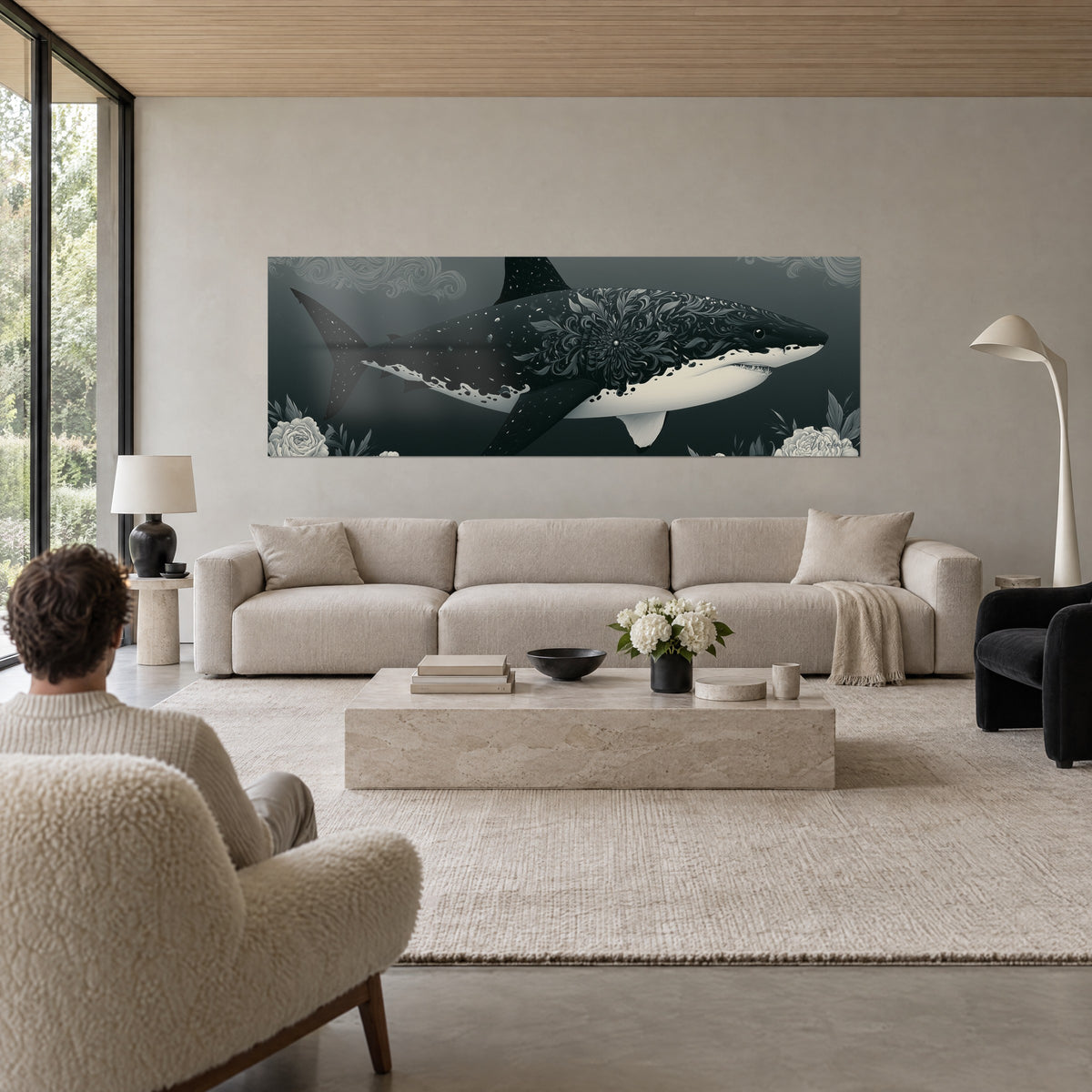 Tableau requin noir ciselé de motifs floraux gris perle, ventre ivoire et fond anthracite, au-dessus d'un canapé dans un salon lumineux
