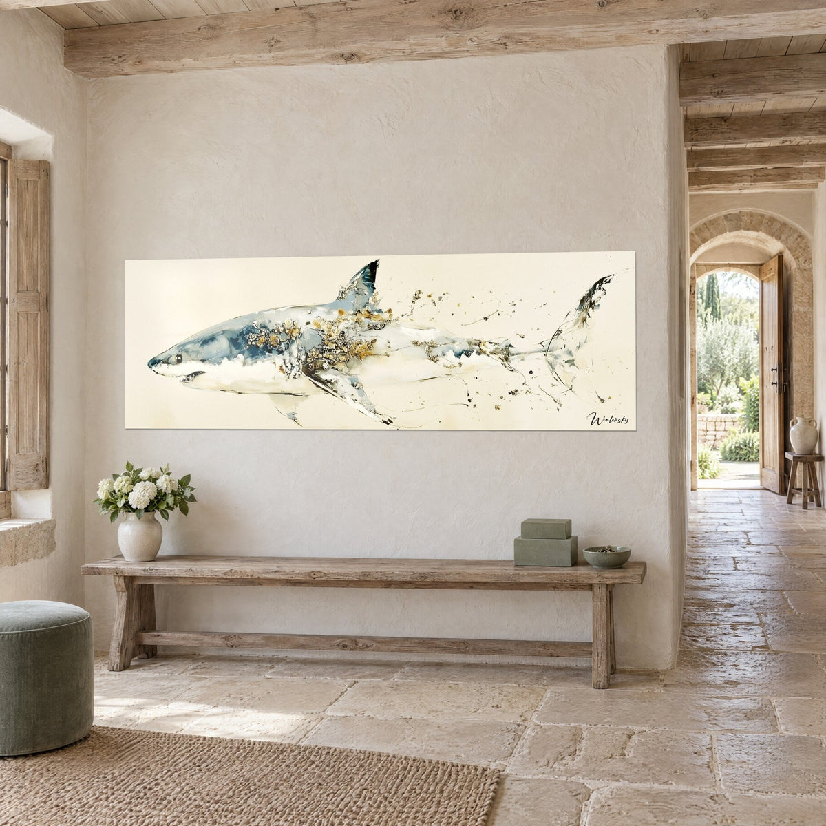 Wall art shark with gold splashes on a cream background, grey-blue back and white belly, three-quarter view in a stone house