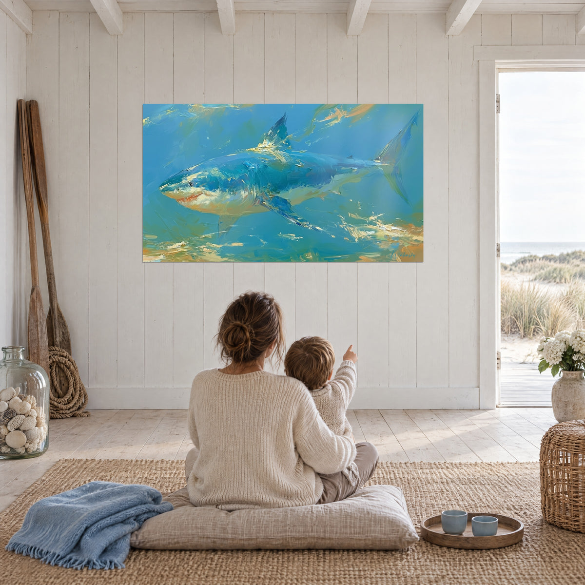 Quadro di uno squalo in nuoto, azzurro cielo e arancio dorato, madre e figlio seduti di spalle su un cuscino grigio, sguardo rivolto in alto
