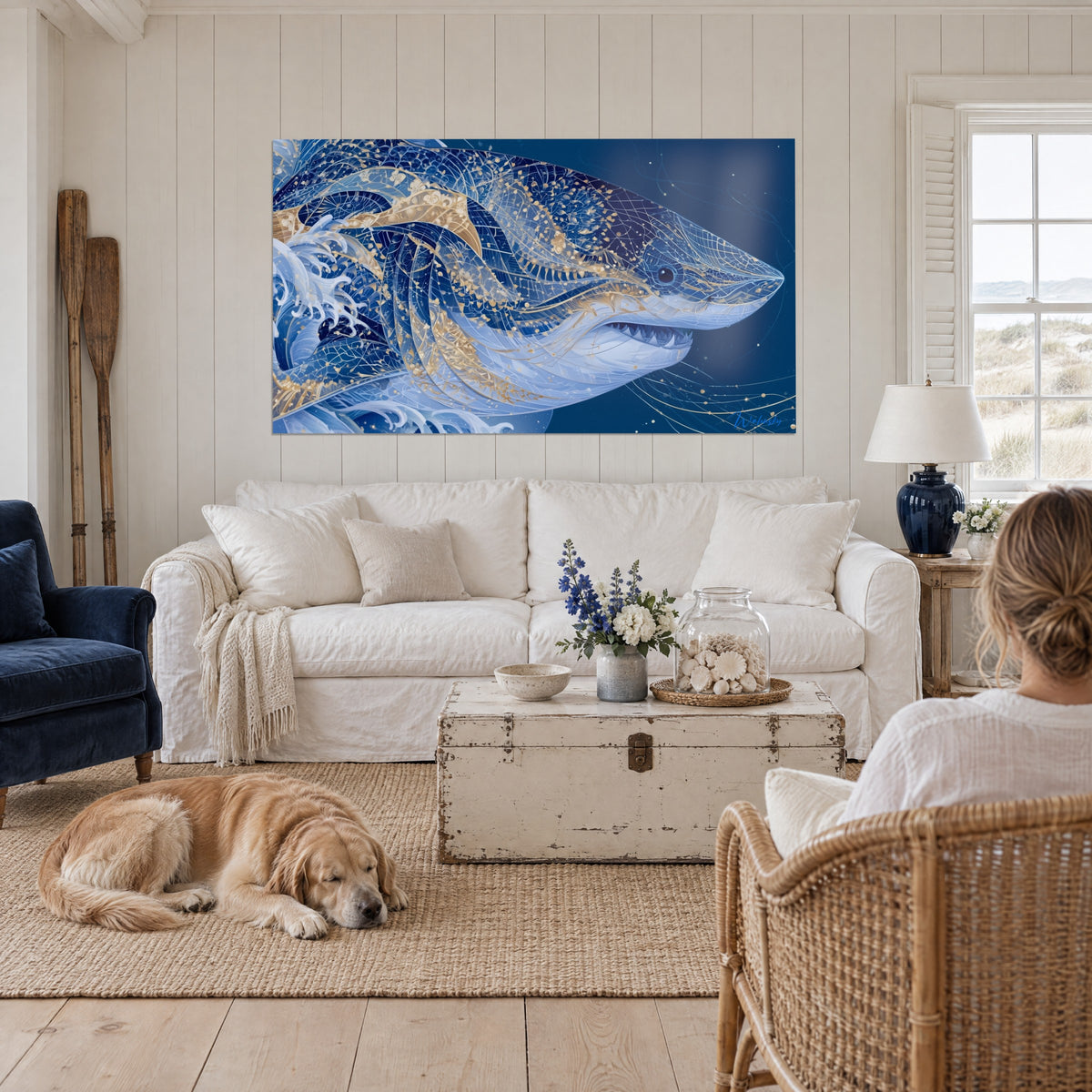 Wall art navy blue shark with gold patterns, open jaw, white foam on the left, above a sofa in a bright living room