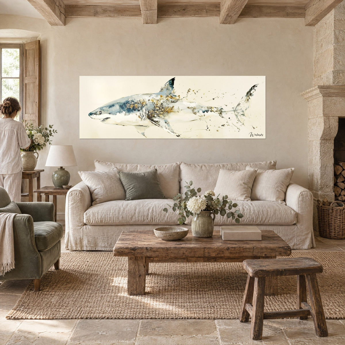 Wall art great white shark in blue and gold watercolor, gold splashes on its flank, two people seen from behind, above a sofa in a bright living room