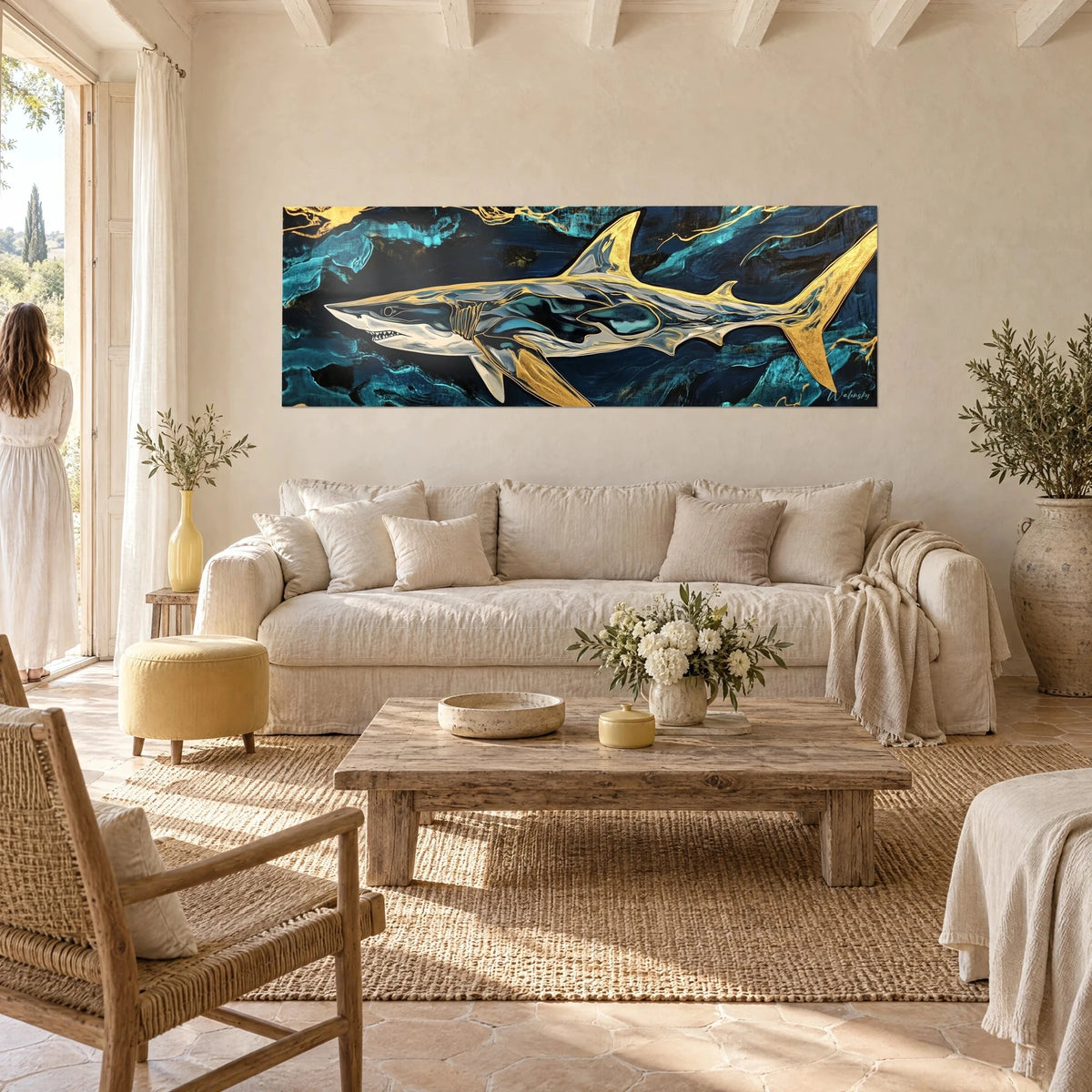 Schilderij haai met gouden vinnen op een nachtblauwe en turquoise achtergrond, vrouw van achteren, boven een bank in een lichte woonkamer