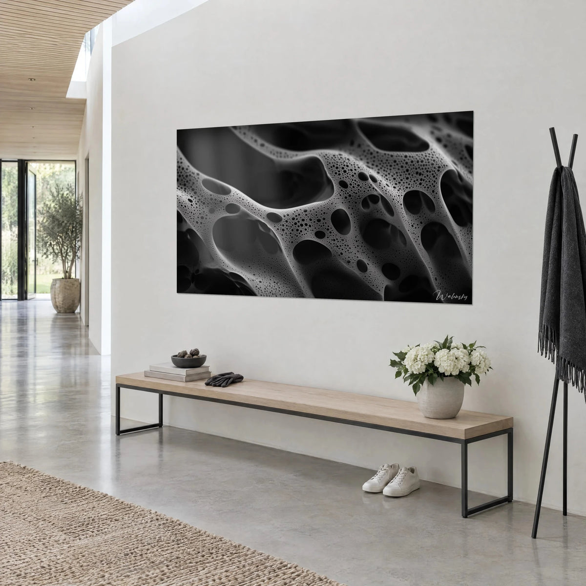 Quadro con struttura alveolare grigia punteggiata di pori neri e riflessi argentati, vista a tre quarti, panca in legno e metallo