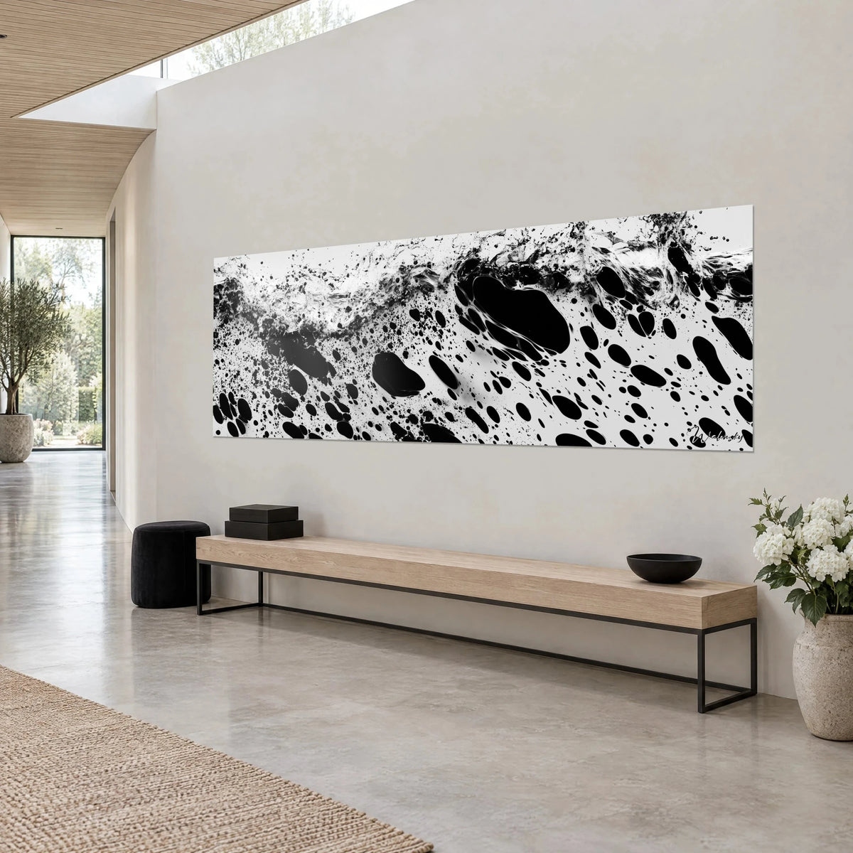Tableau vague figée en noir et blanc, grandes taches d'encre luisantes et écume grise, accroché dans un séjour de pierre claire