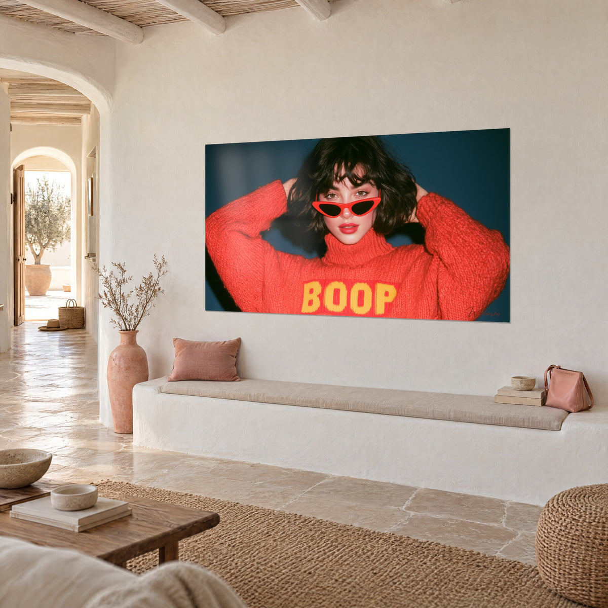 Wall art in retro portrait style of a brunette bob, hands in her hair, red-coral and navy sweater, white Mediterranean-style wall