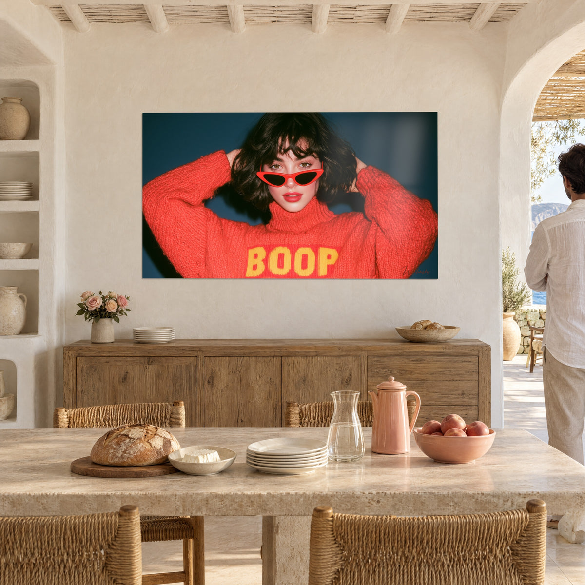 Wall art of a brunette pin-up in red sunglasses, coral knit with yellow BOOP lettering, deep blue background, whitewashed wall, stone floor