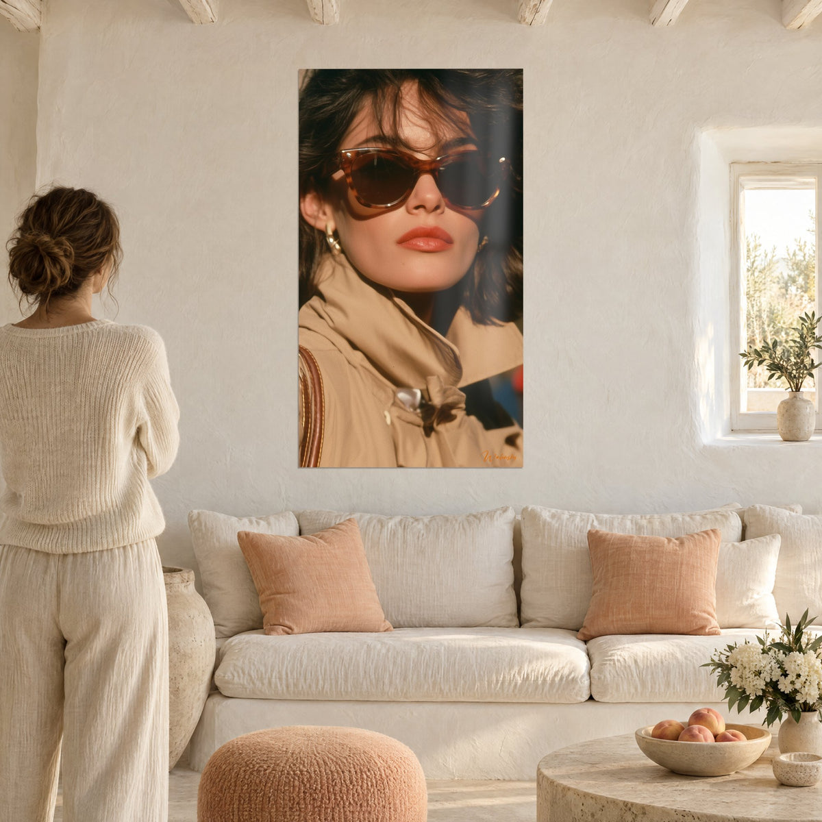 Πίνακας glamour πορτρέτο μιας μελαχρινής με γυαλιά από χελώνα, κοραλλί χείλη και μπεζ τρέγκ, γυναίκα από πίσω, πάνω από καναπέ σε φωτεινό σαλόνι