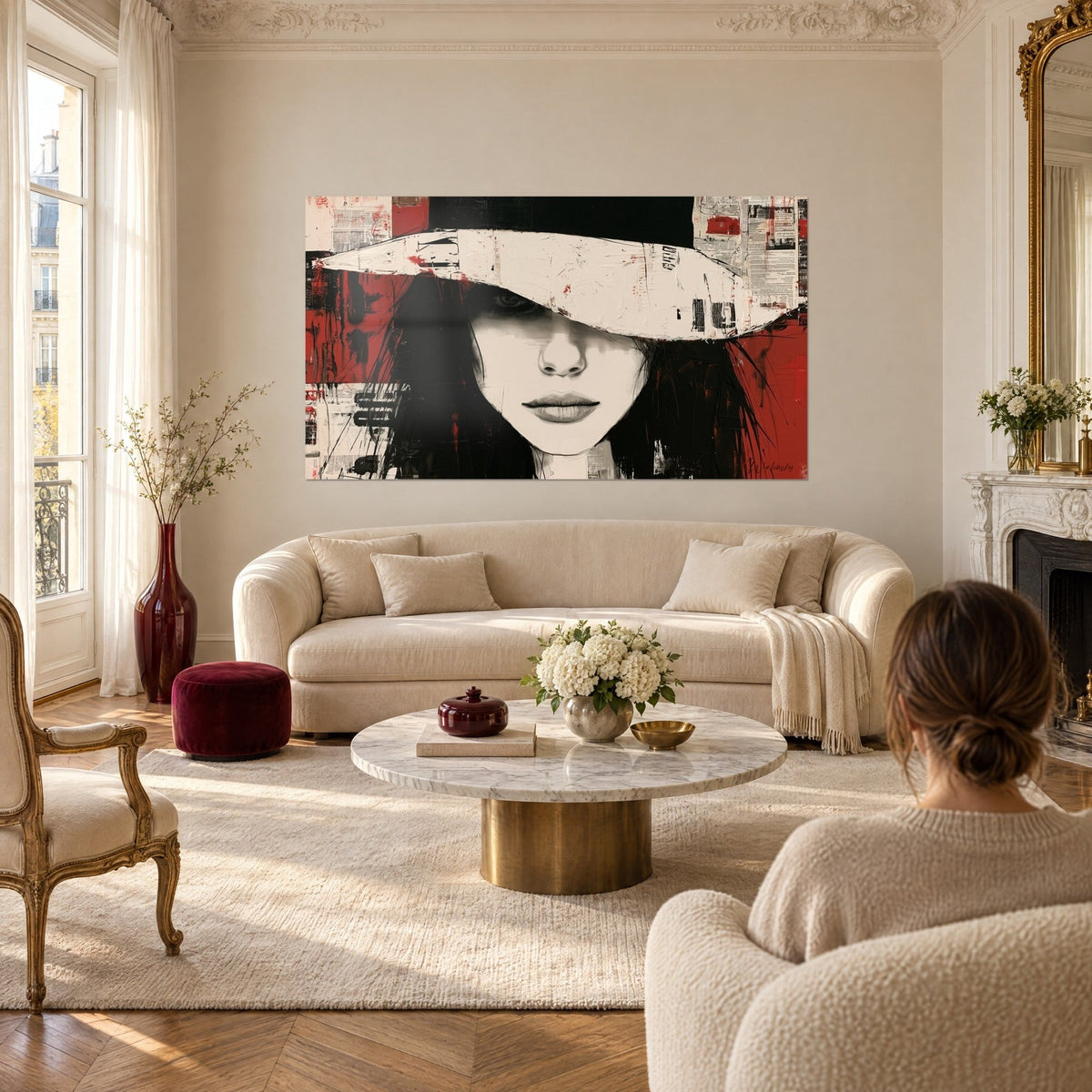 Cuadro rostro femenino bajo un sombrero crema, planos de rojo y negro, collage de periódicos, sobre un sofá en un salón luminoso