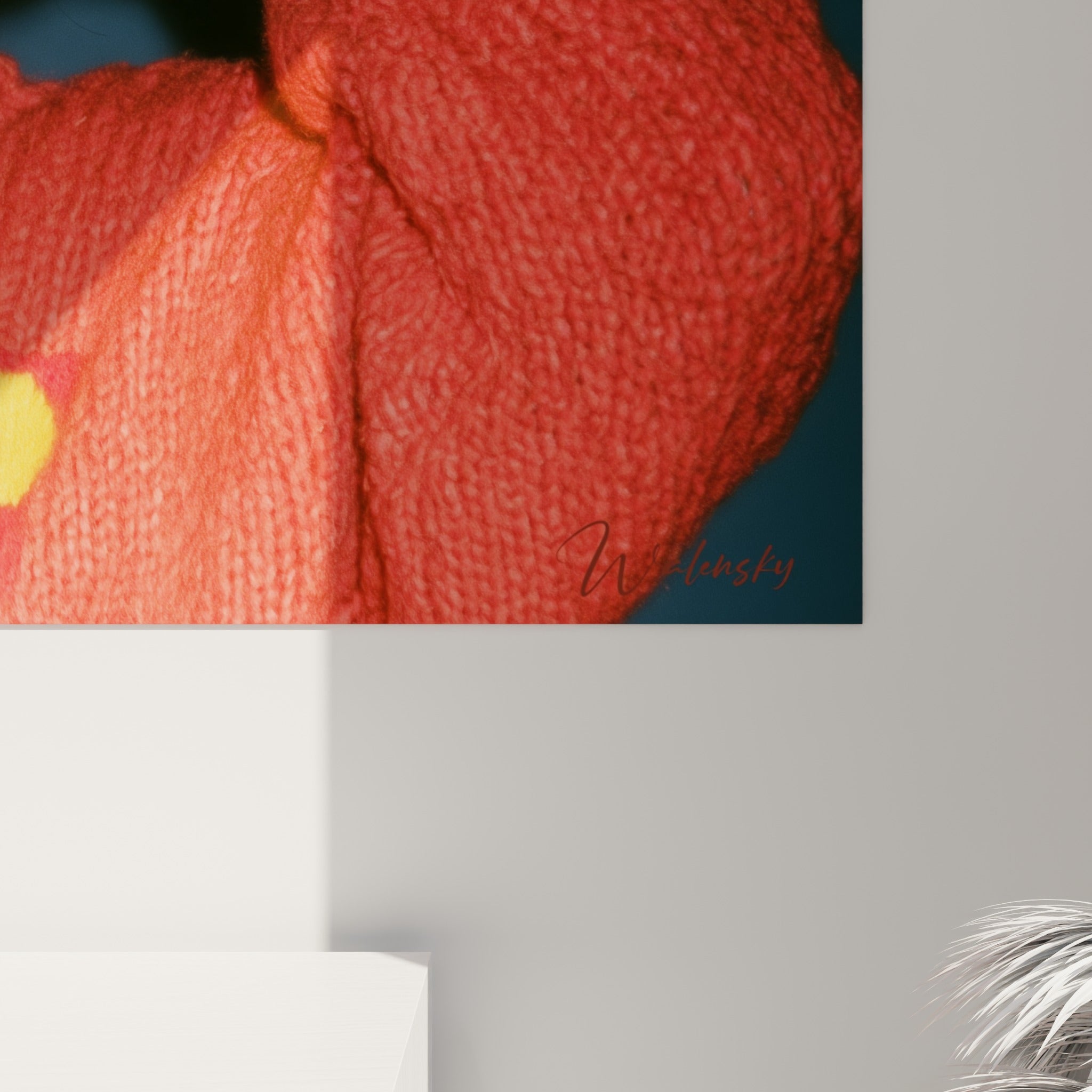 Grain photographique révélant le tricot corail épais et le rouge vif des lunettes en gros plan