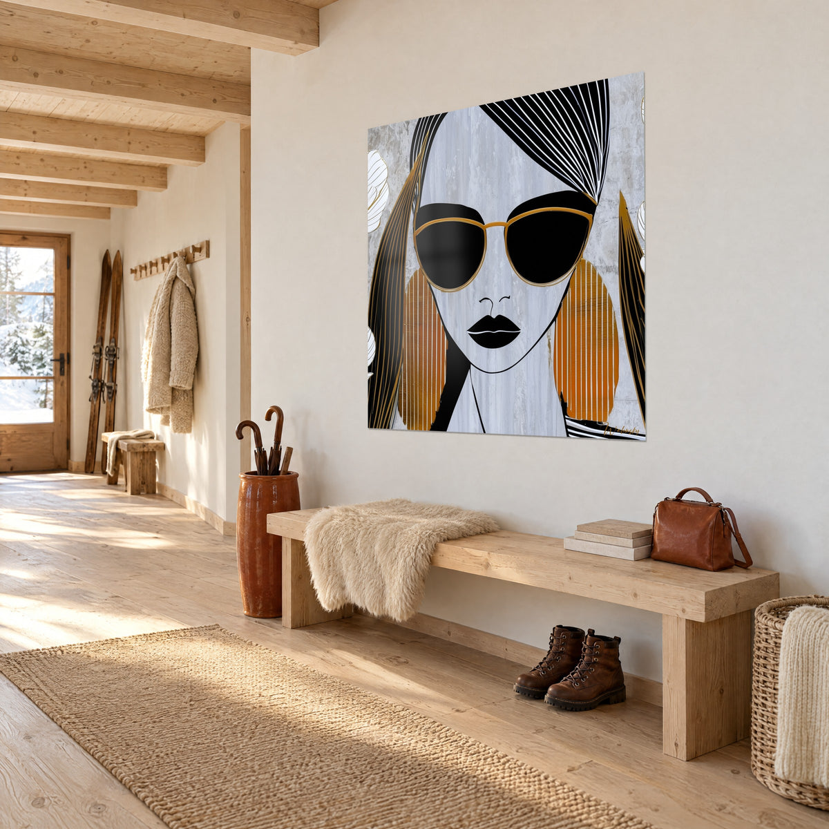 Cuadro rostro de mujer gráfico, labios negros y marco dorado sobre fondo gris hormigón, colgado junto a un banco de madera en la entrada del chalet