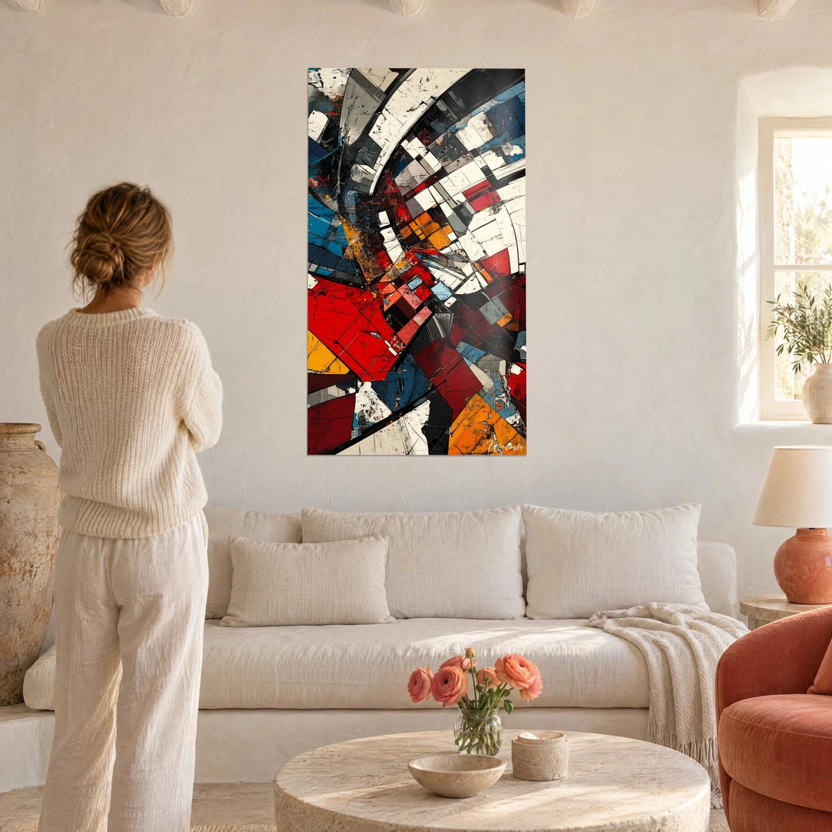 Tableau éclats géométriques rouge vif et bleu acier, arcs ivoire fracturés, femme de dos, au-dessus d'un canapé dans un salon lumineux
