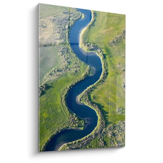 Un quadro paesaggistico che rappresenta un fiume sinuoso che attraversa prati verdeggianti, con tonalità di blu, verde e beige, e una texture liscia che contrasta con rilievi vegetali dettagliati.

