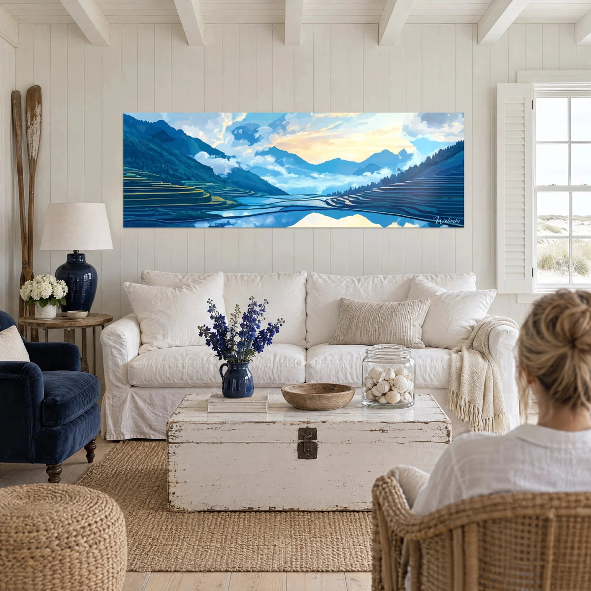 Tableau rizières en terrasses sous un ciel bleu et or, deux personnes de dos au-dessus d'un canapé dans un salon lumineux
