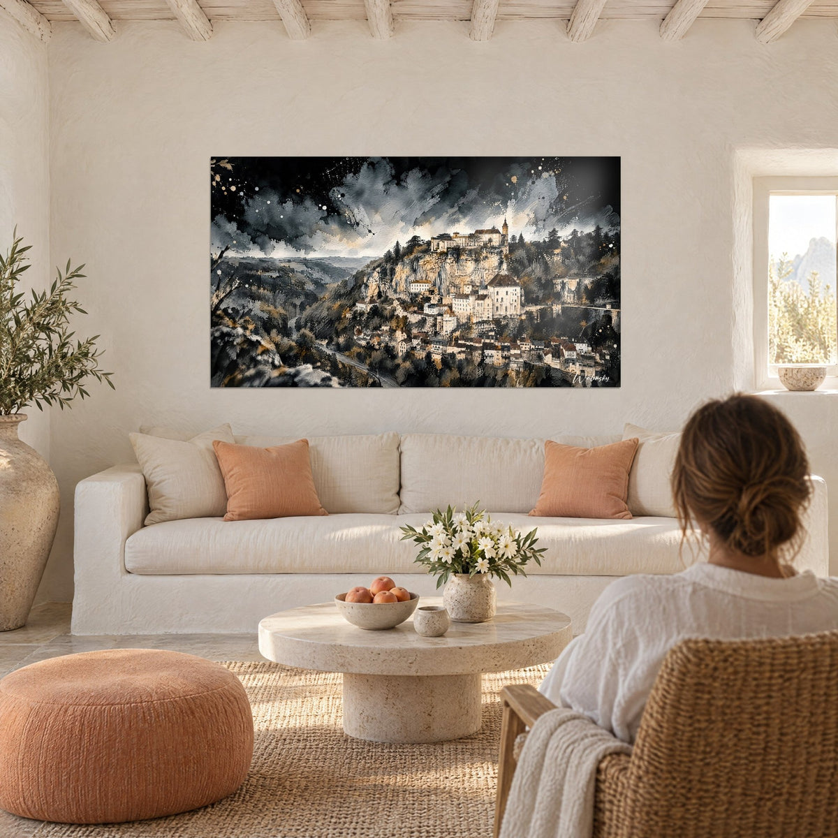 Gemälde einer mittelalterlichen Felsenstadt auf ockerfarbener Klippe, anthrazitfarbener Gewitterhimmel, eine Frau von hinten, über einem Sofa in einem hellen Wohnzimmer