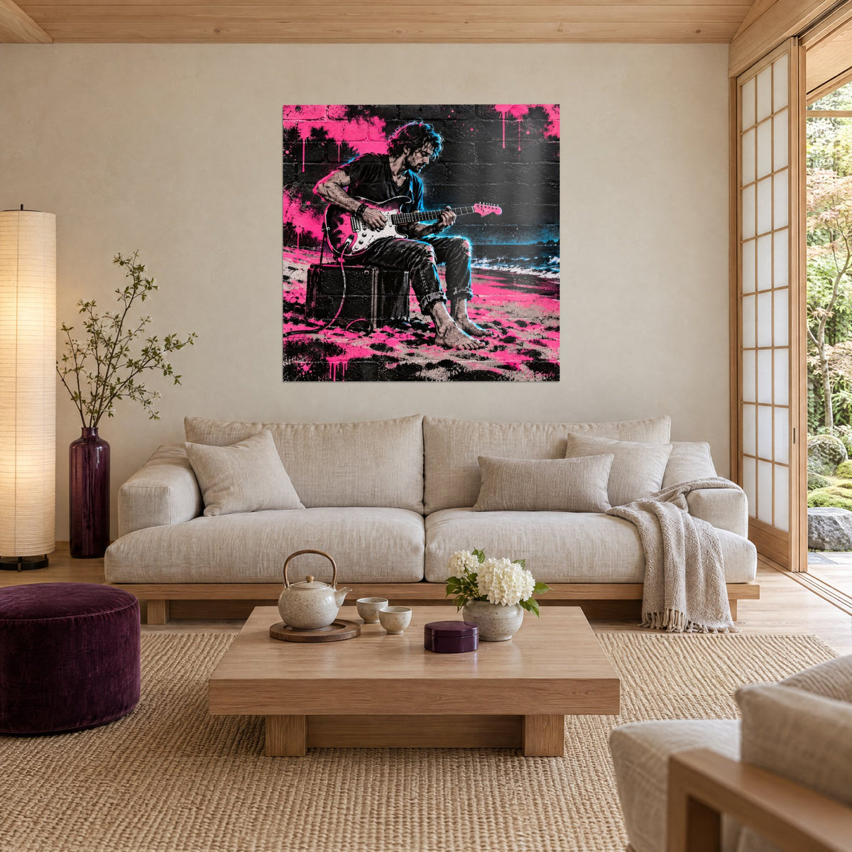Tableau guitariste assis sur un ampli face aux vagues, rose fluo et noir, briques éclaboussées, au-dessus d'un canapé dans un salon lumineux