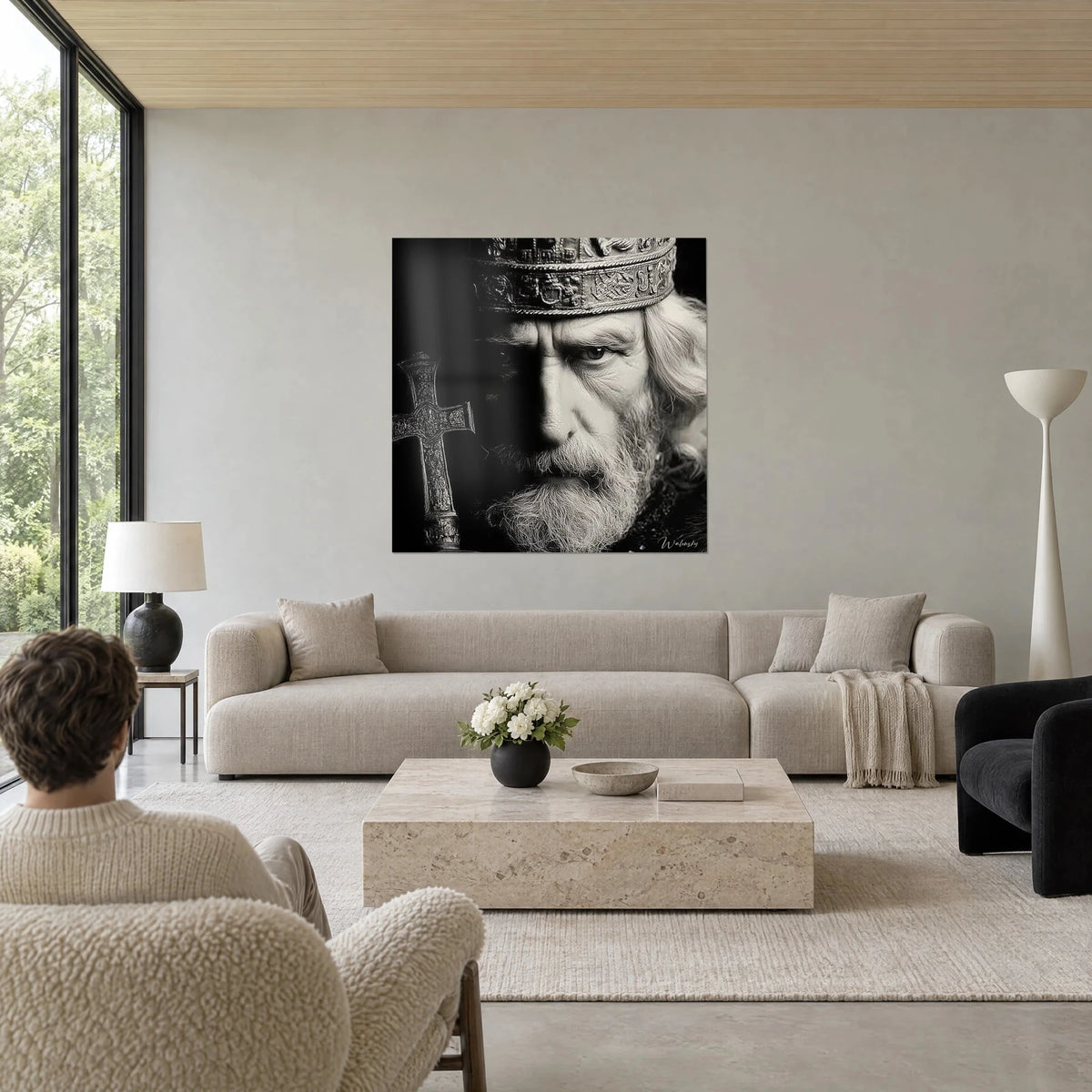 Wall art of a sovereign with a silver beard, chiseled crown and dark cross, black and white, above a sofa in a bright living room