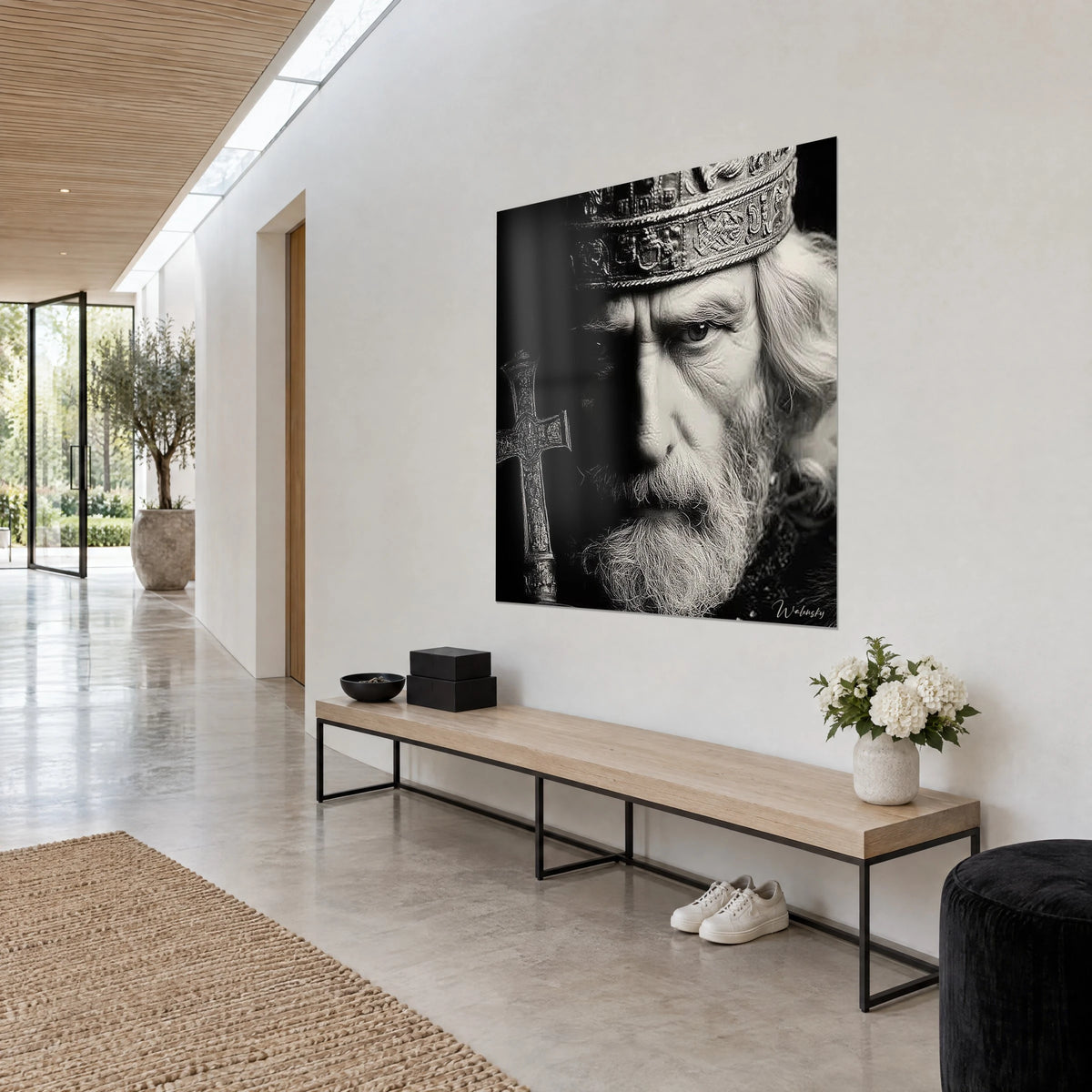 Cuadro retrato de un anciano rey de mirada seria, barba blanca y sombra oscura en el rostro, pared blanca de un pasillo luminoso