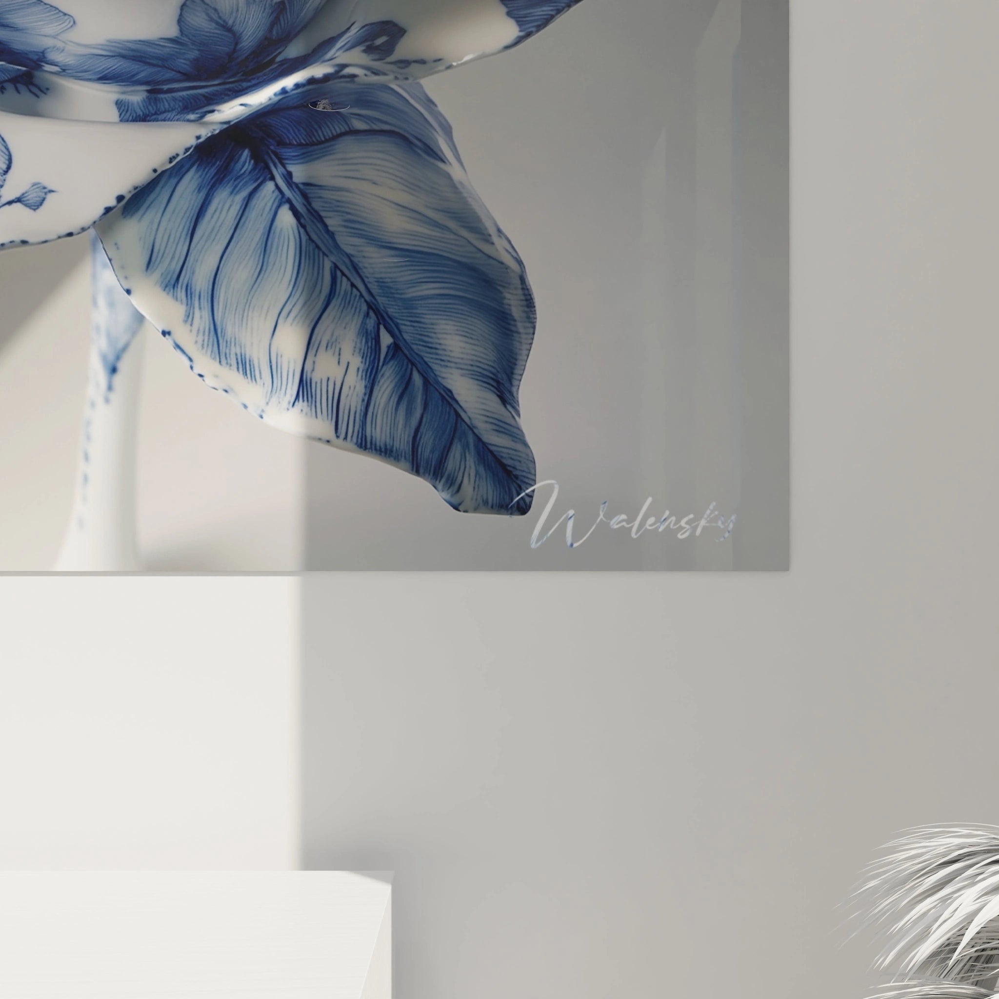 Un tableau porcelaine dévoilant une fleur aux pétales blancs ornés de motifs bleus minutieux, à la surface brillante captant la lumière, créant un contraste saisissant entre les deux teintes principales et offrant une impression de relief sculptural malgré la planéité du support.
