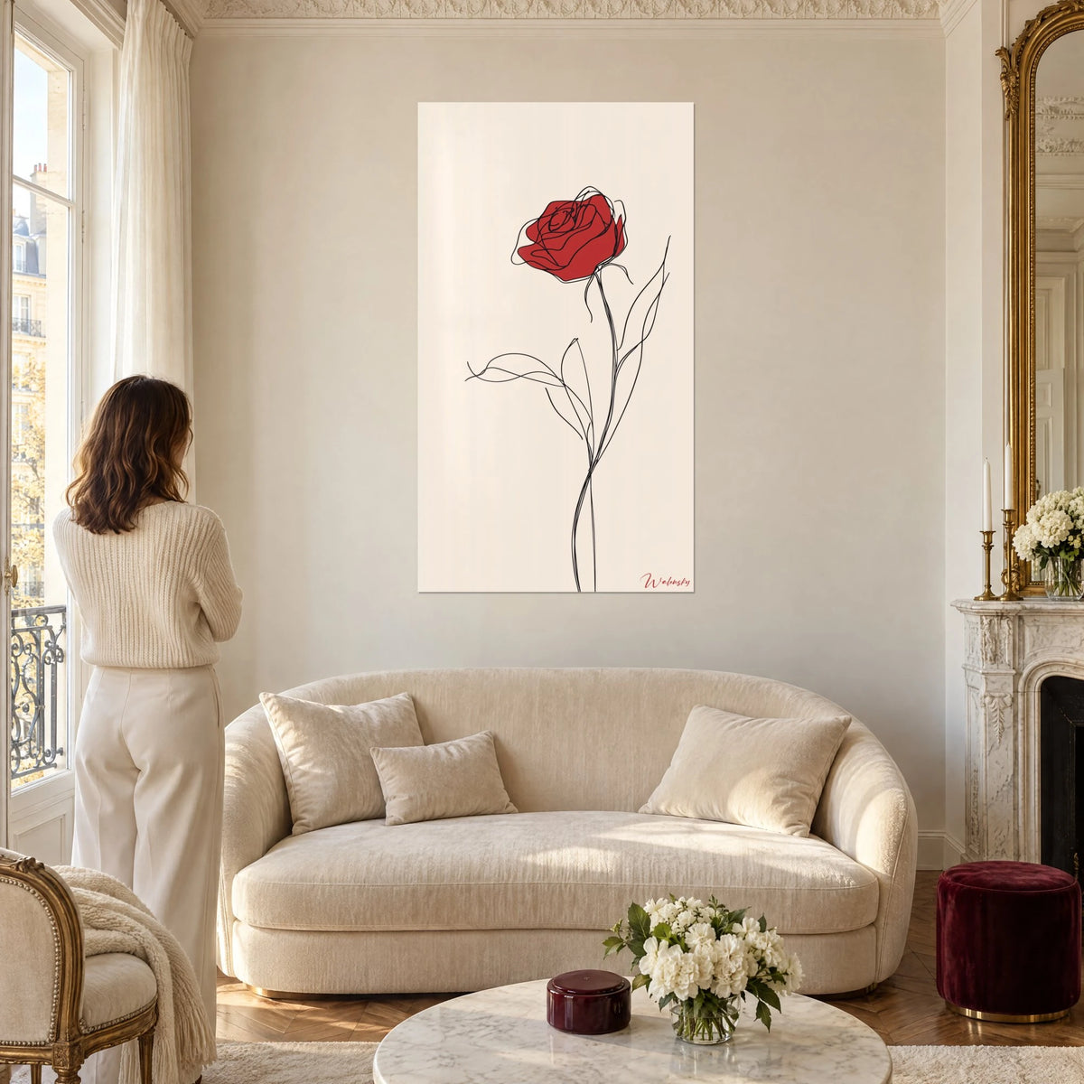Quadro rosa rosso carminio con tratto nero continuo, fondo crema, stelo slanciato, sopra un divano in un soggiorno luminoso