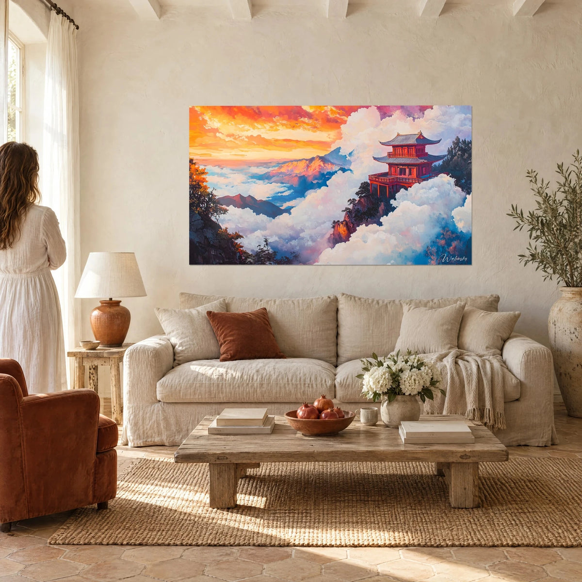 Tableau pagode vermillon posée sur un rocher, mer de nuages blancs et ciel orangé, au-dessus d'un canapé dans un salon lumineux