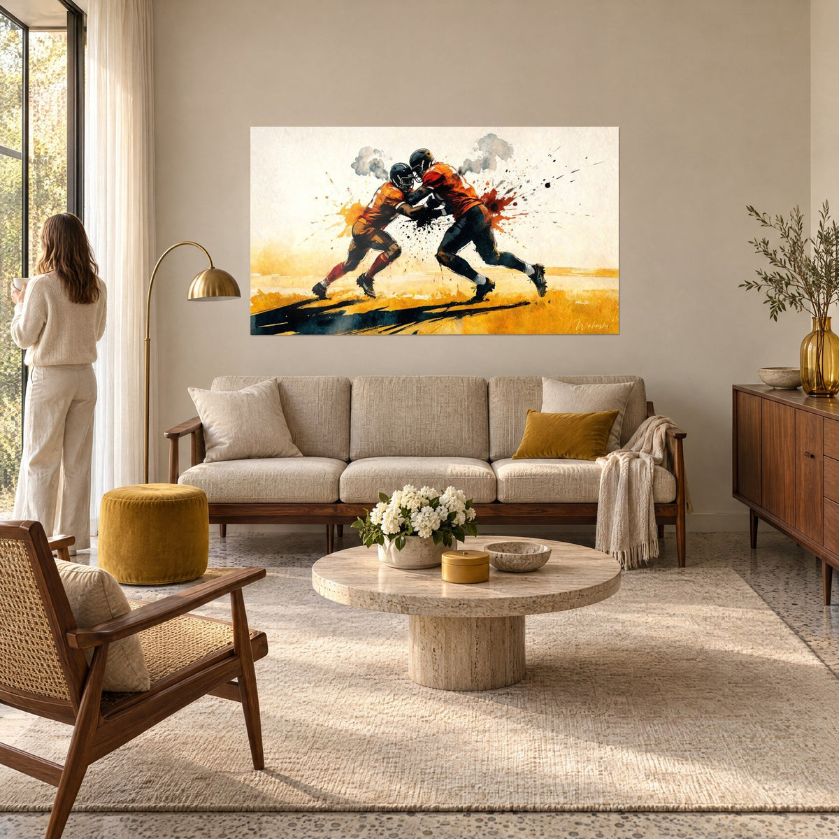 Tableau plaqueurs casqués s'écrasant dans l'ocre et l'orange, éclaboussures noires, une femme de dos, au-dessus d'un canapé dans un salon lumineux