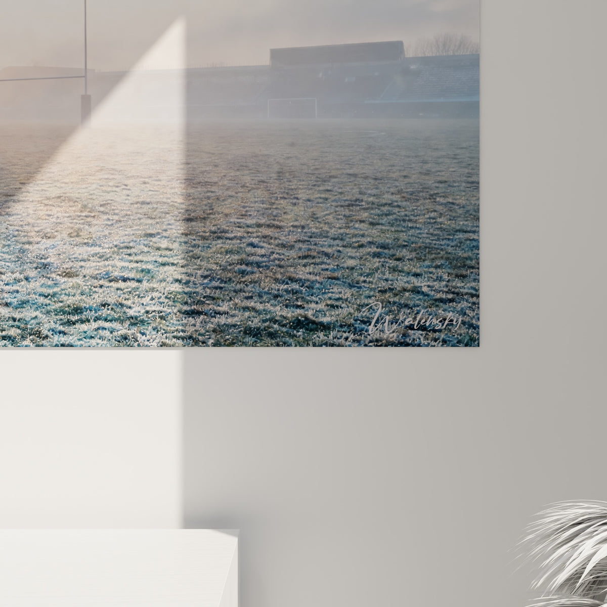 Détail du grain photographique révélant la brume gris bleuté et la lueur orangée du soleil sur le tableau accroché