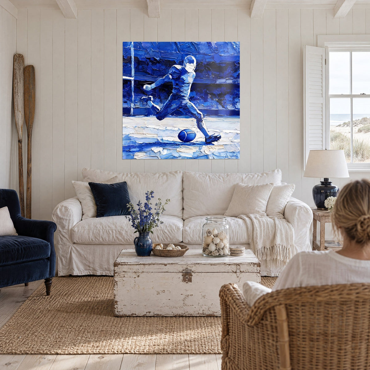 Gemälde eines Rugbyspielers im vollen Schuss, kobaltblau und cremeweiß, dicker Farbauftrag, über dem Sofa in einem hellen Wohnzimmer