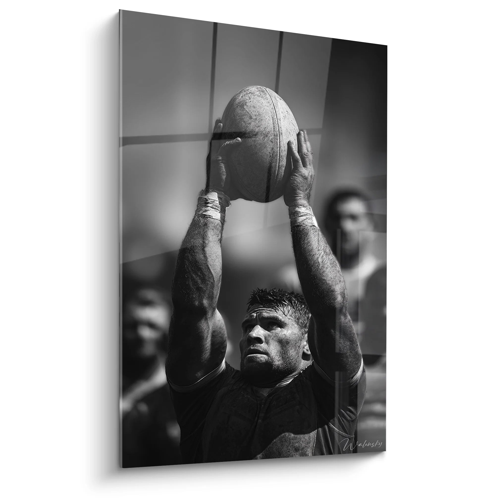 Tableau rugby noir et blanc montrant joueur tenant ballon oval au-dessus tête en pleine concentration