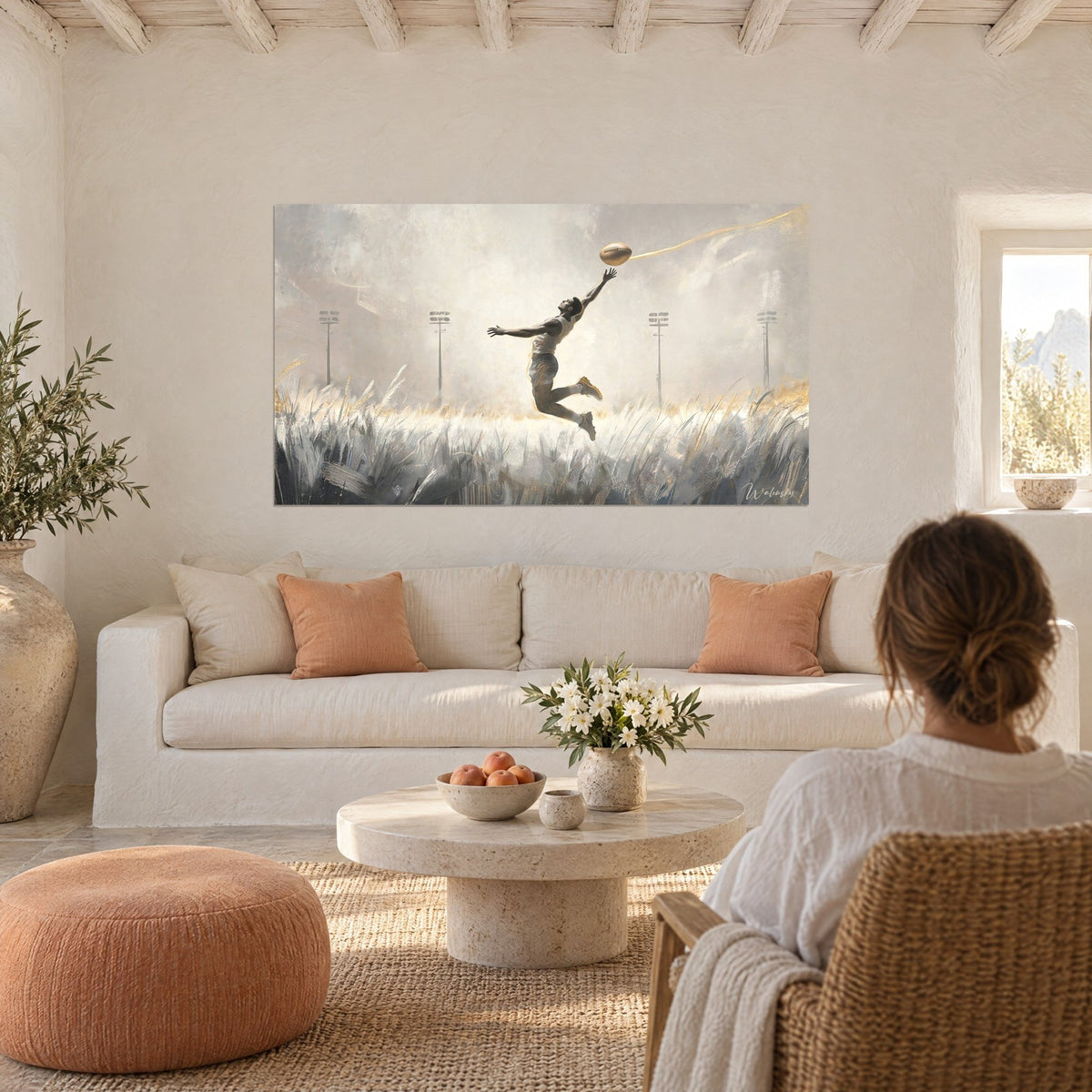 Tableau rugbyman en plein saut, bras tendu vers un ballon doré, herbes grises et traînée d'or, au-dessus d'un canapé dans un salon lumineux